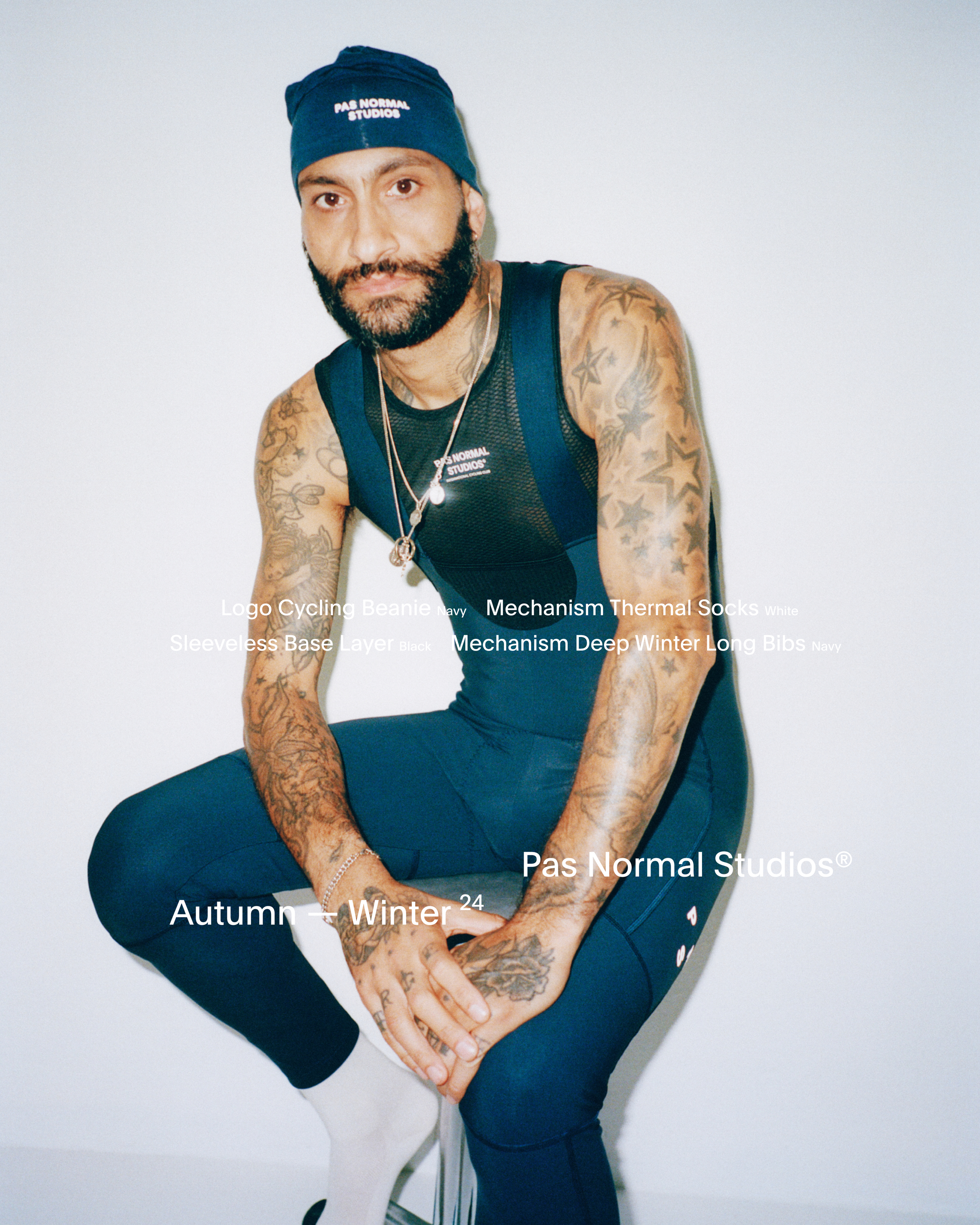 Model wearing Mechanism Sleeveless Base Layer in navy with matching beanie, studio shot