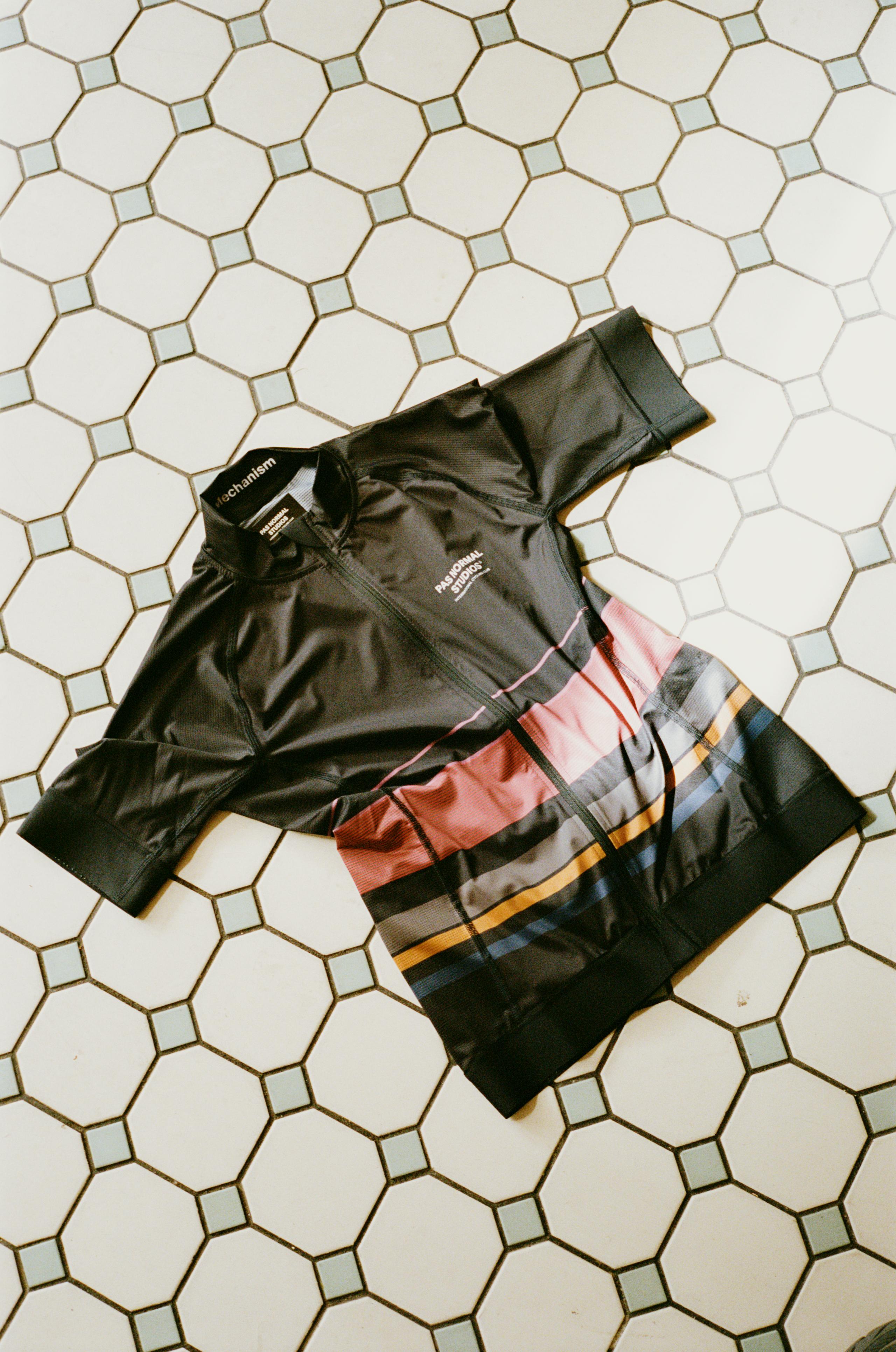Men's Mechanism Jersey in dark green with multicolored graphic print on hexagonal tile floor
