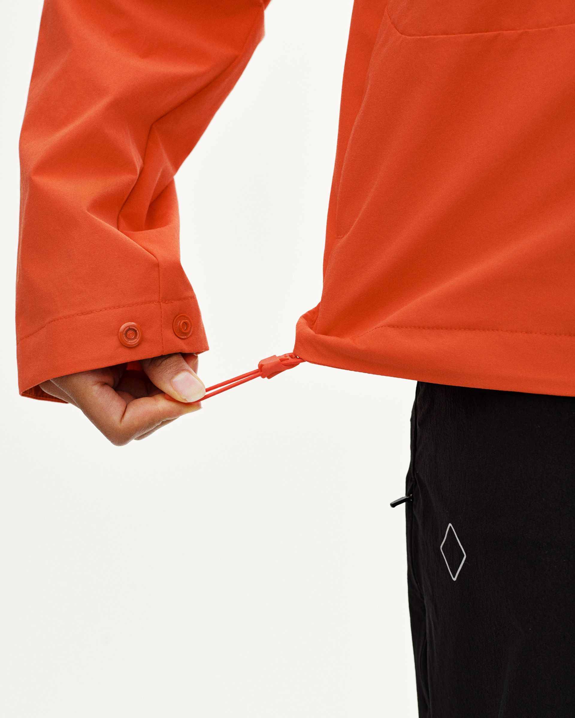 Orange Off-Race Utility jacket, detail view showing adjustable hem with snap buttons and drawstring