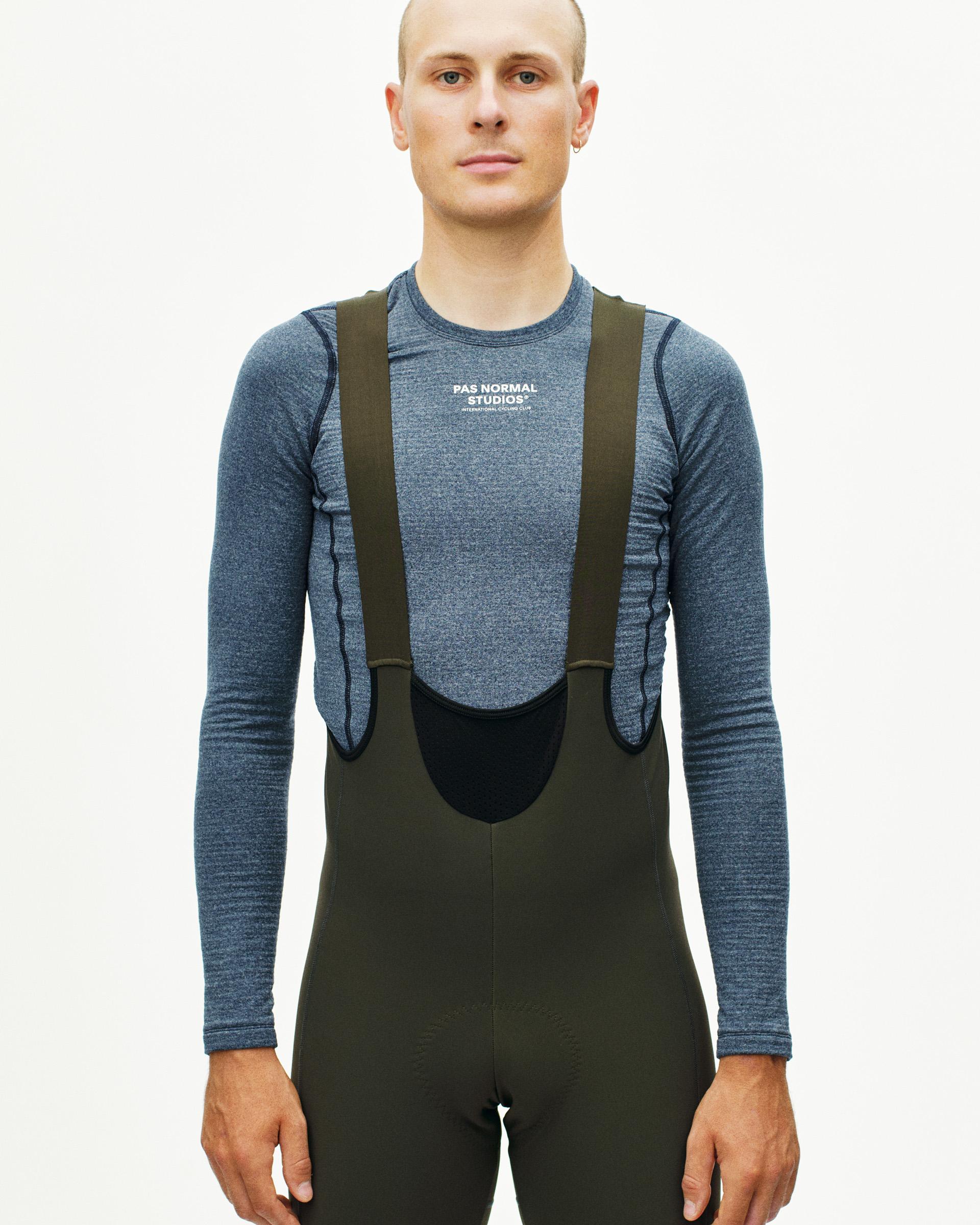 Dark Olive Mechanism Deep Winter Long cycling bibs on model with high chest panel and shoulder straps