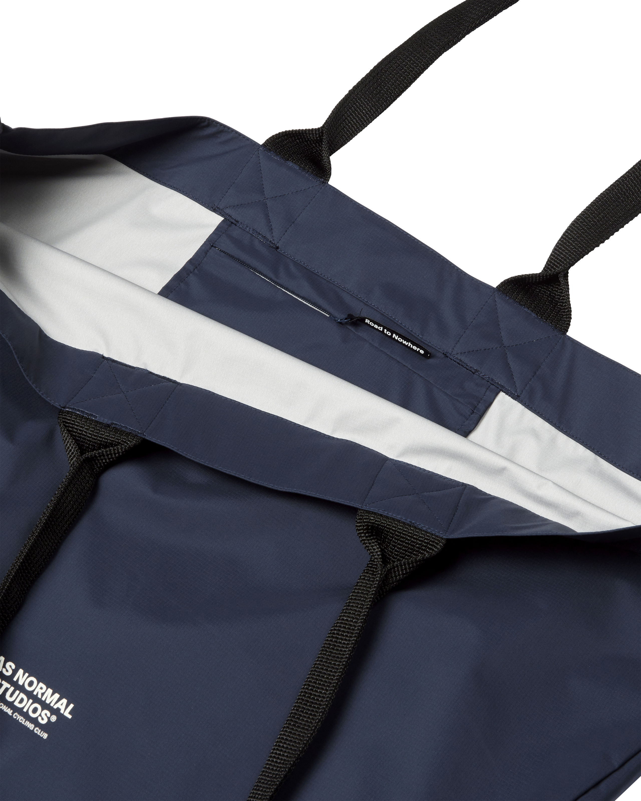 Navy Logo Shield tote bag, flat lay showing quilted panels and black webbing straps