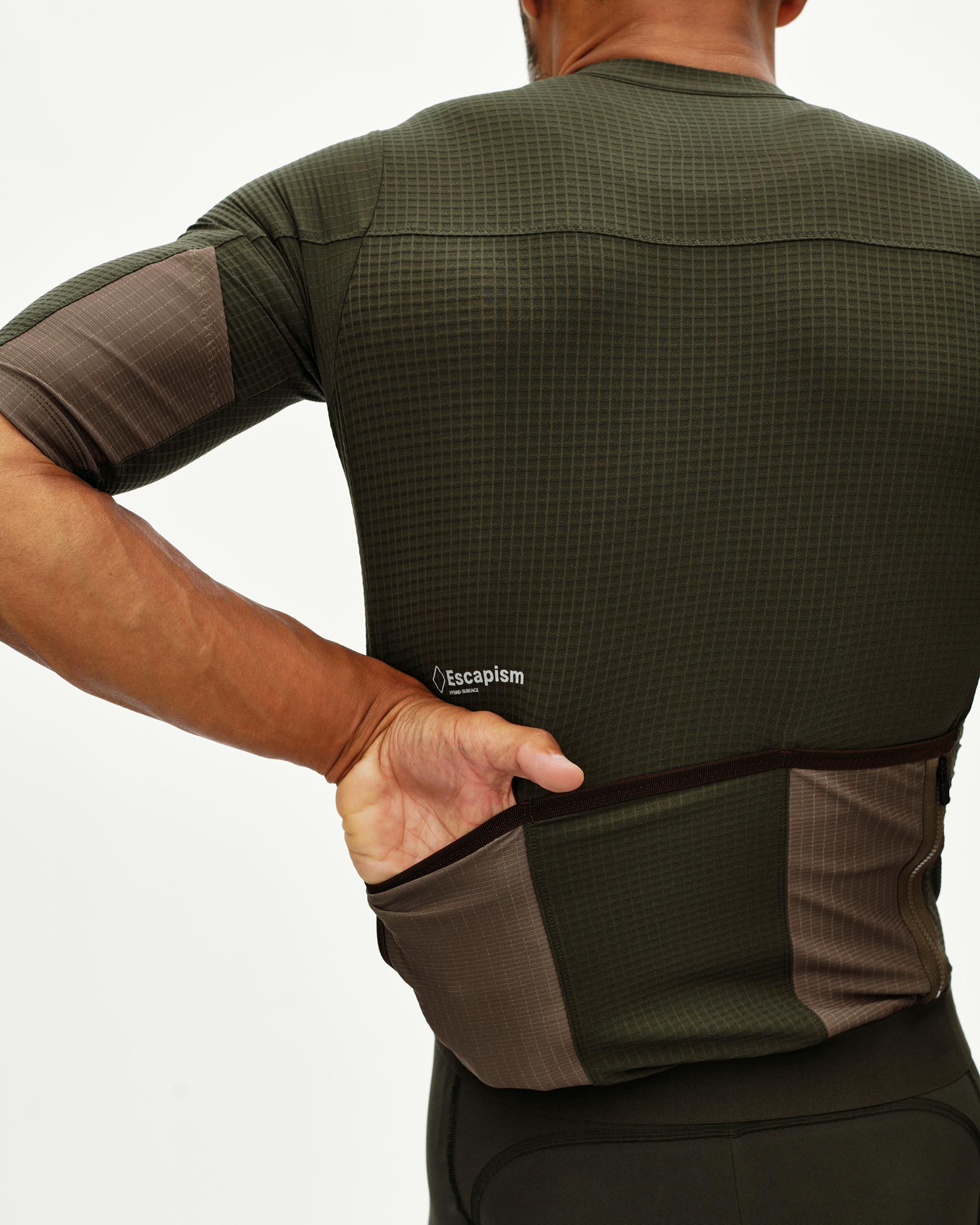 Dark Olive Escapism cycling jersey on model, rear view showing back pockets with contrast brown panel