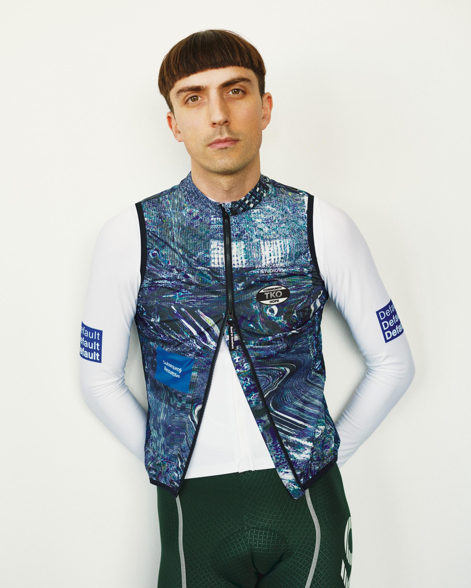 Human Error Blue T.K.O. Mechanism Stow Away cycling gilet on model, front view with abstract all-over print