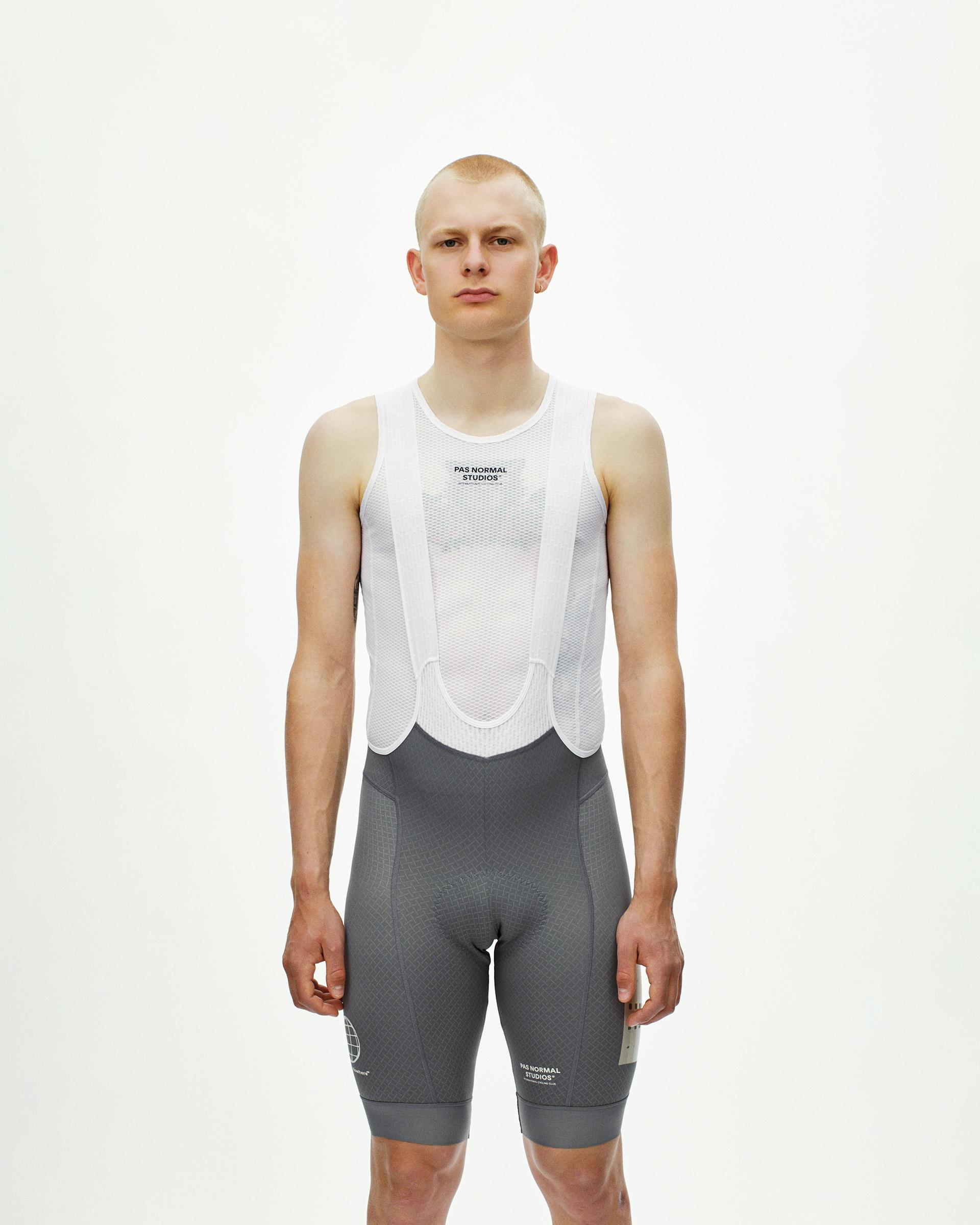 Medium Grey Mechanism Logo cycling bibs on model, front view with white mesh bib straps