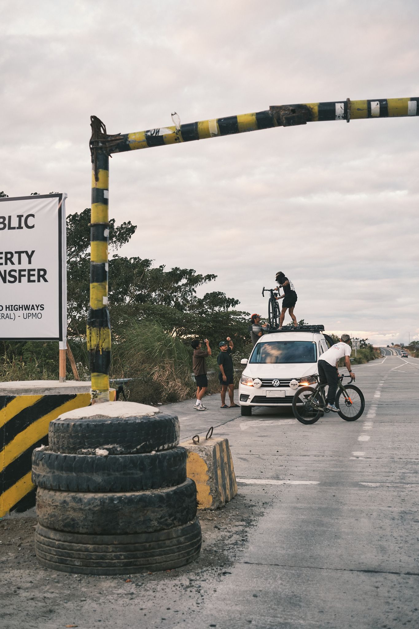 Cyclists at roadside checkpoint with bikes and support vehicle