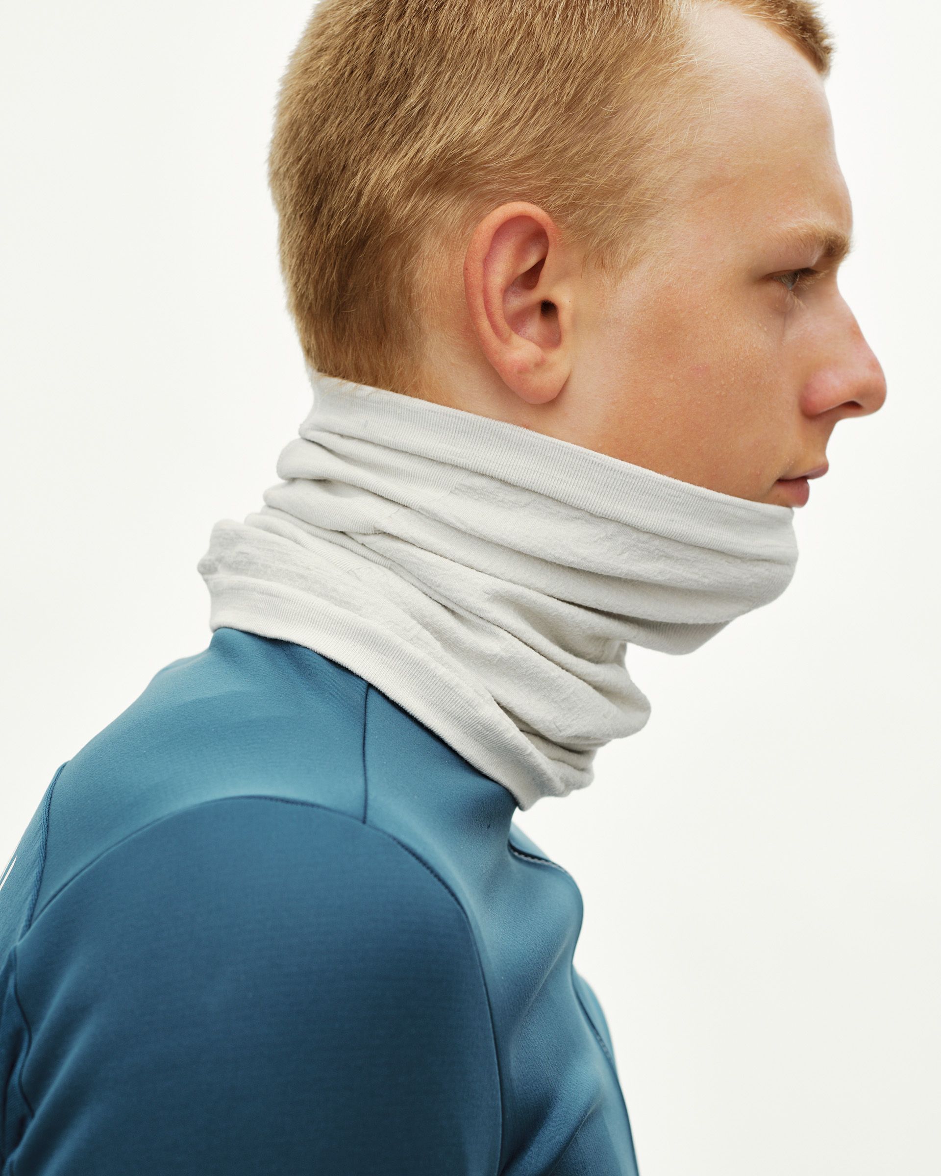 Misty Grey Essential Logo Merino Knit necktube on model, side view worn around neck and chin