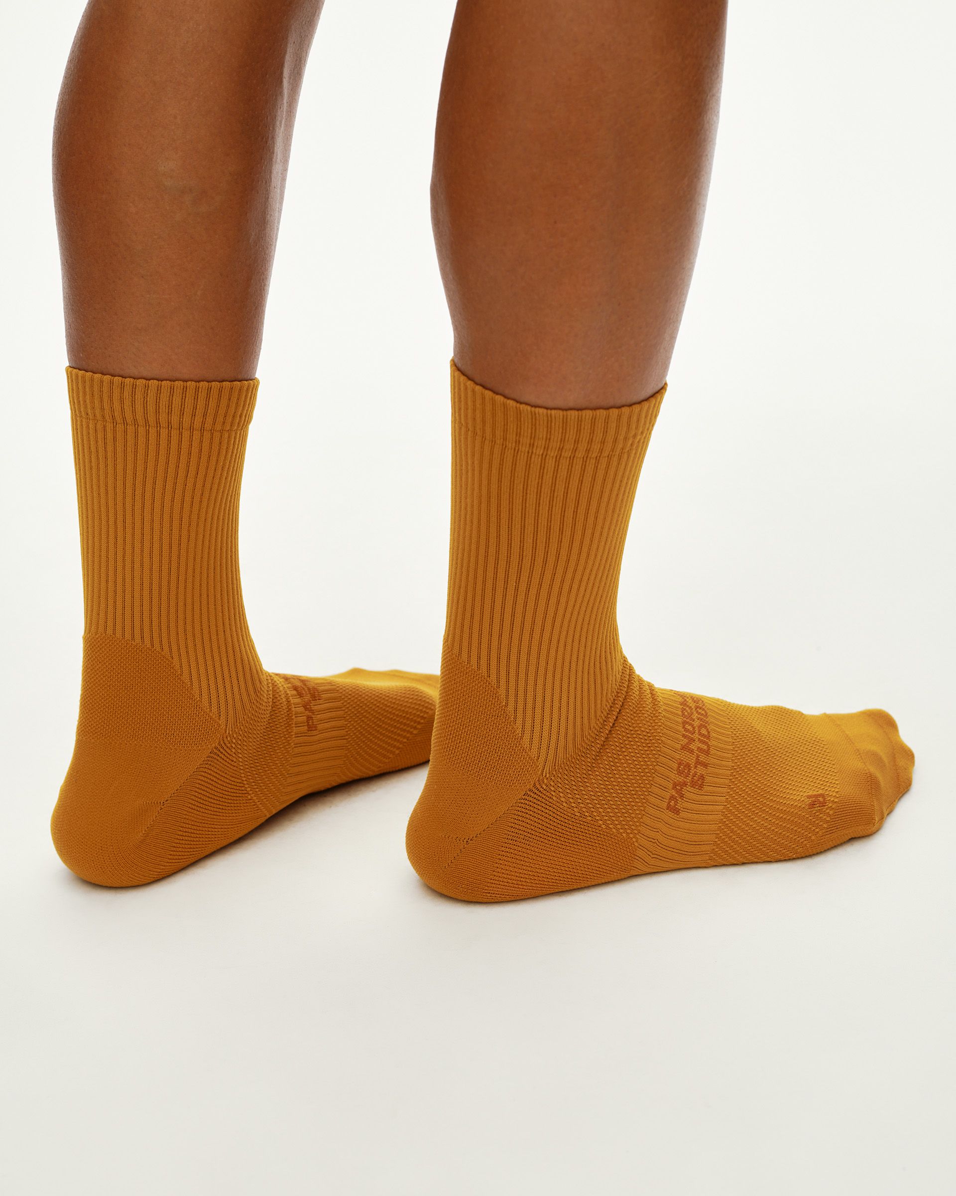 Ochre Balance cycling socks, rear view on model showing ribbed cuff and tonal branding