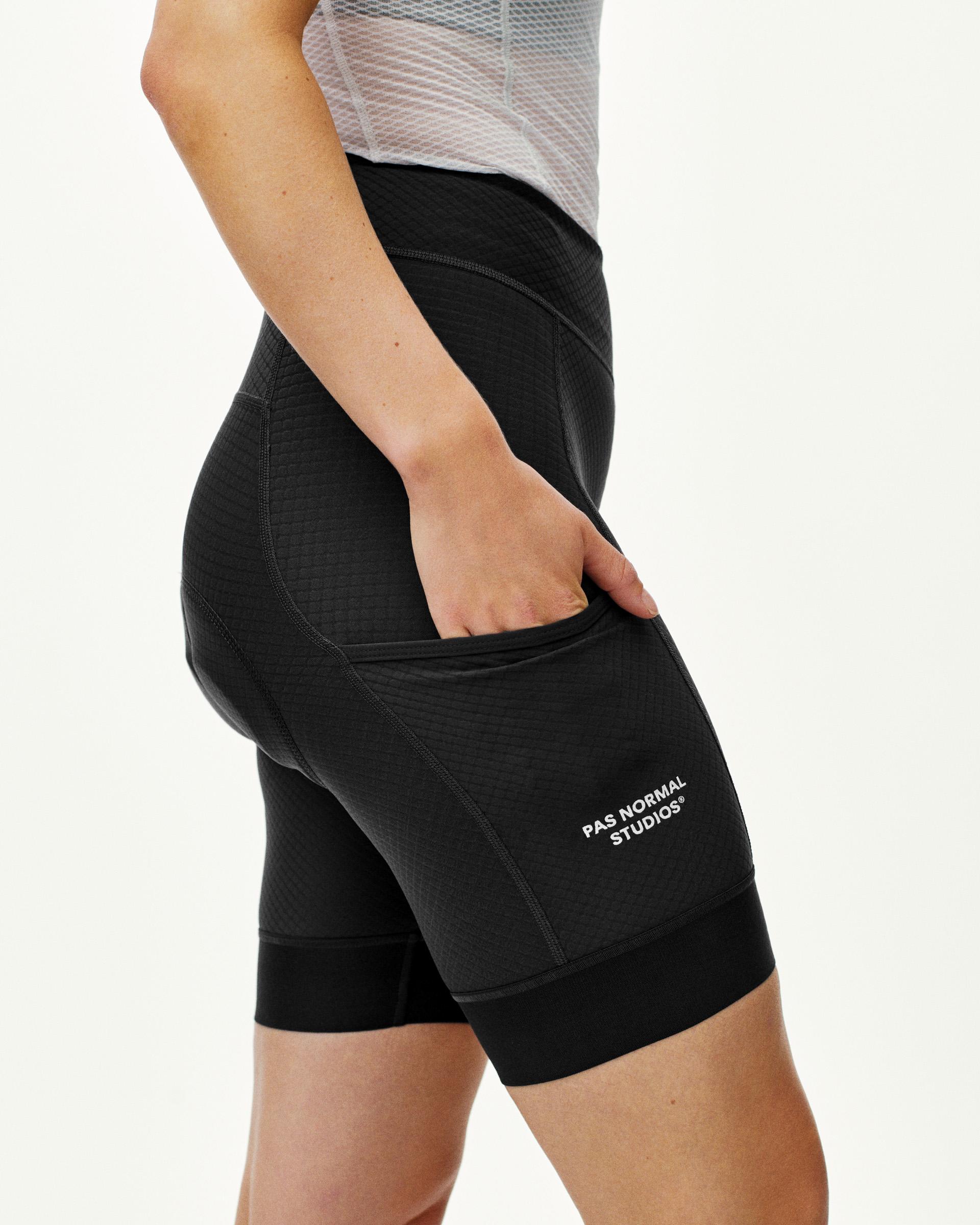 Black Essential short tights on model showing side cargo pocket with hand inserted