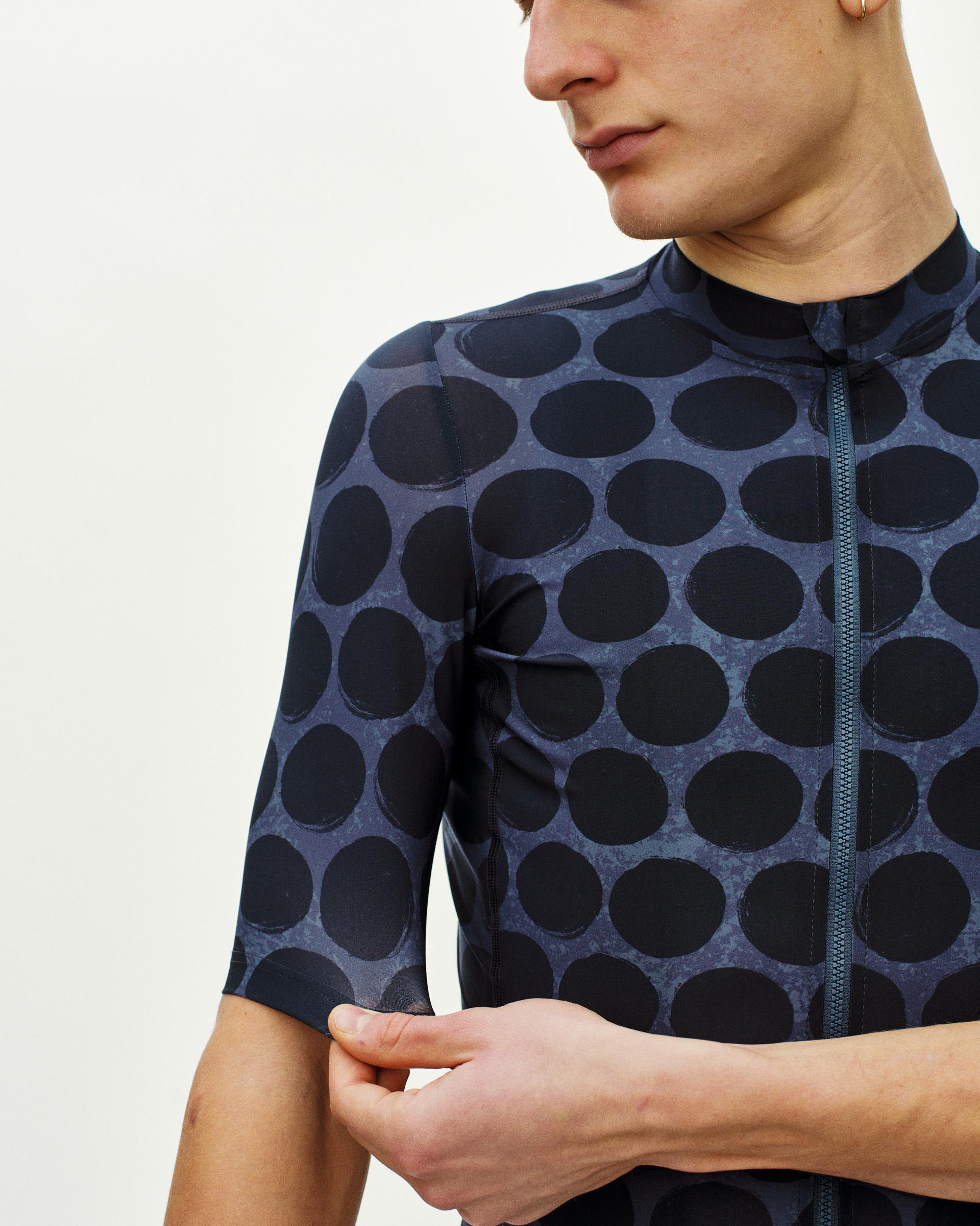 Dark Navy Essential cycling jersey on model, front detail view with large dot print and centre zip