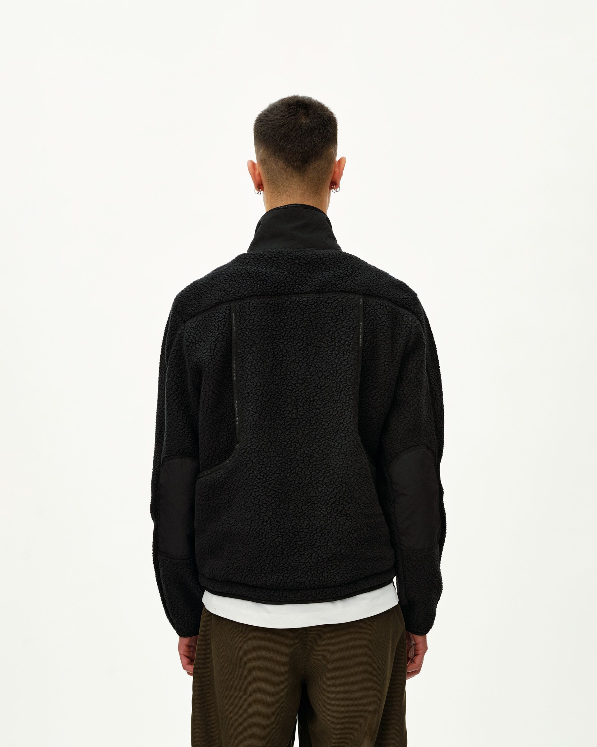 Black Off-Race Pile Fleece jacket on model, rear view with contrast nylon panels