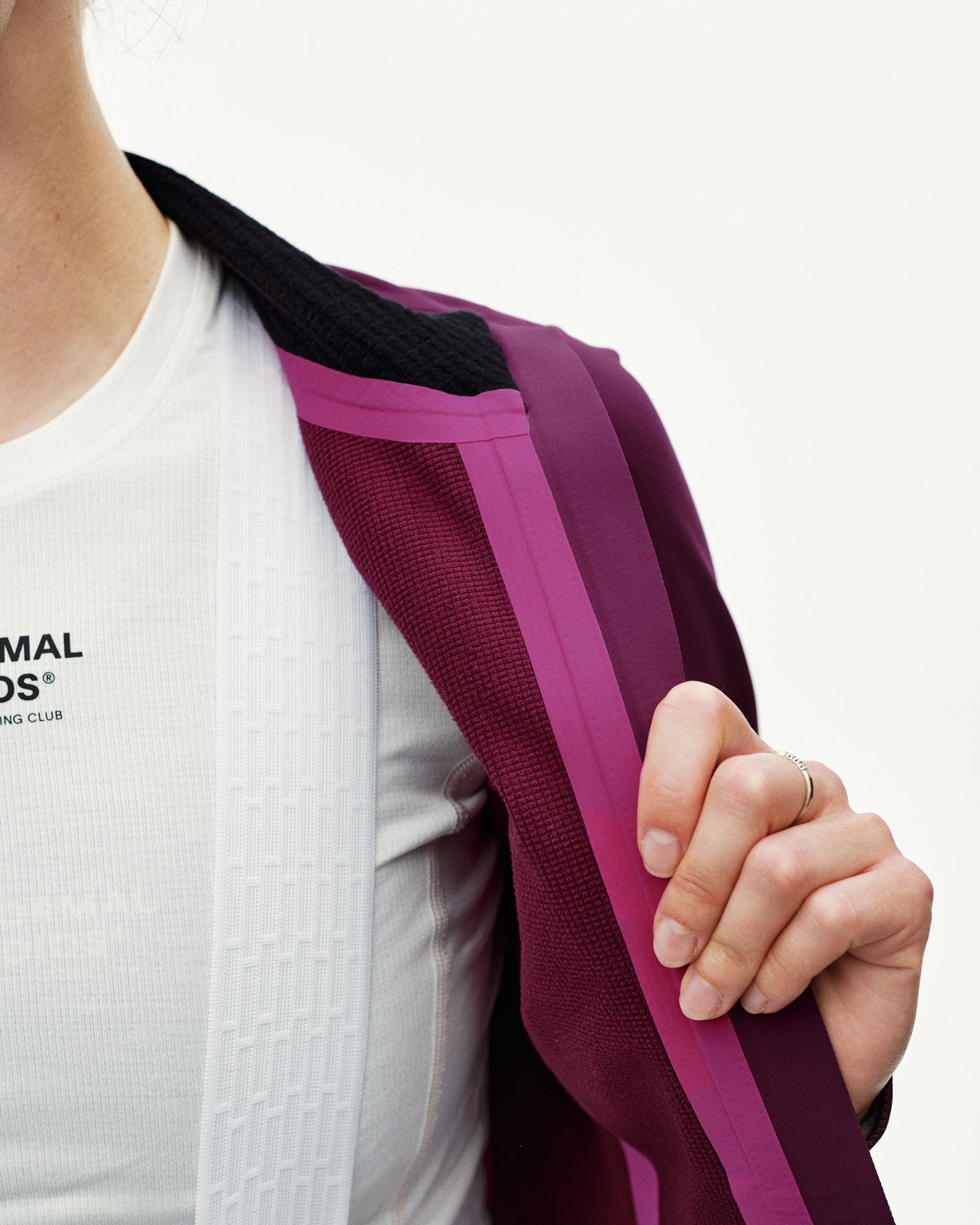 Dark Purple women's thermal cycling jacket, detail view of open front zip showing pink taped seam and textured inner lining