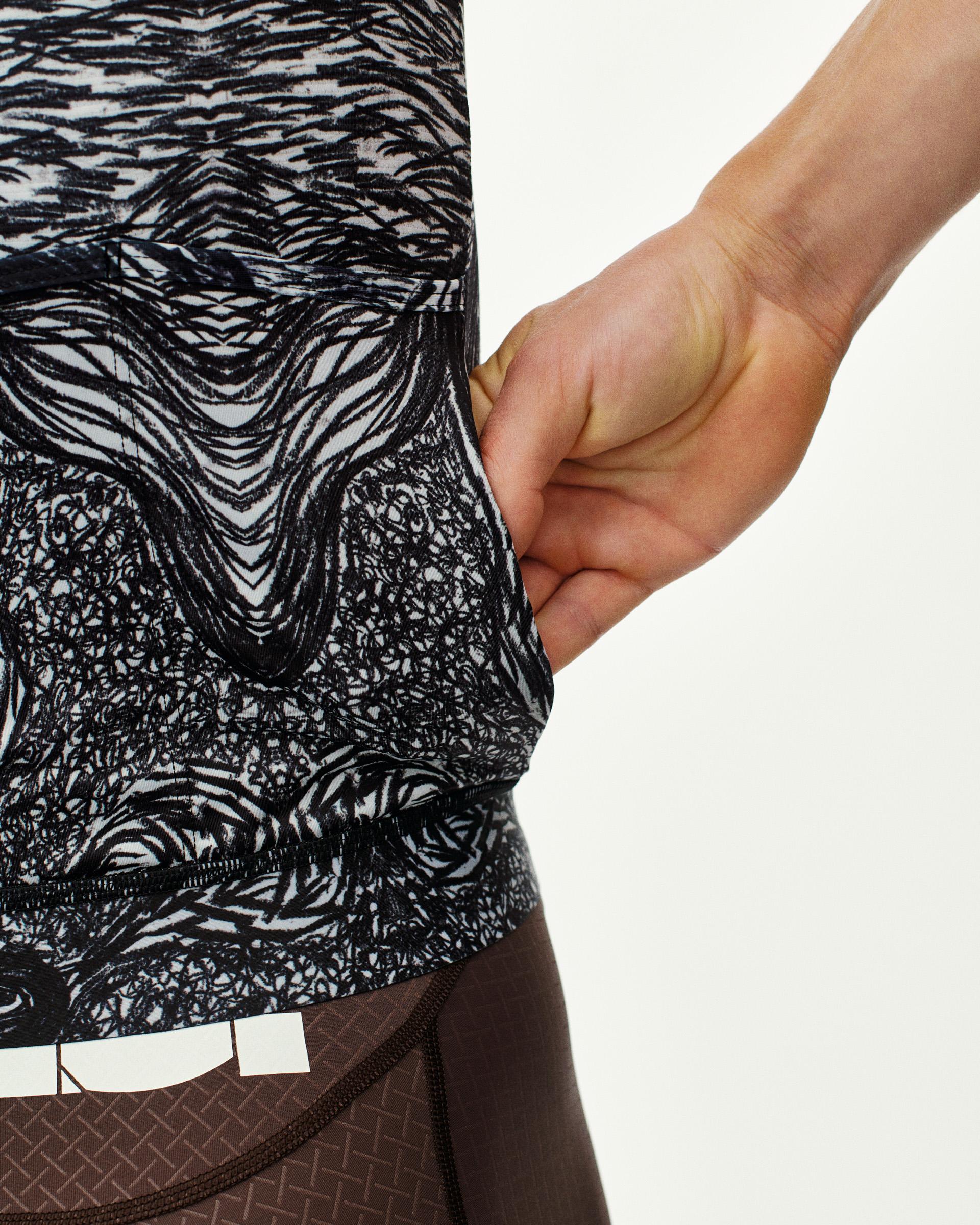 Iron Grey T.K.O. Mechanism cycling jersey, side detail on model showing rear pocket opening with abstract print