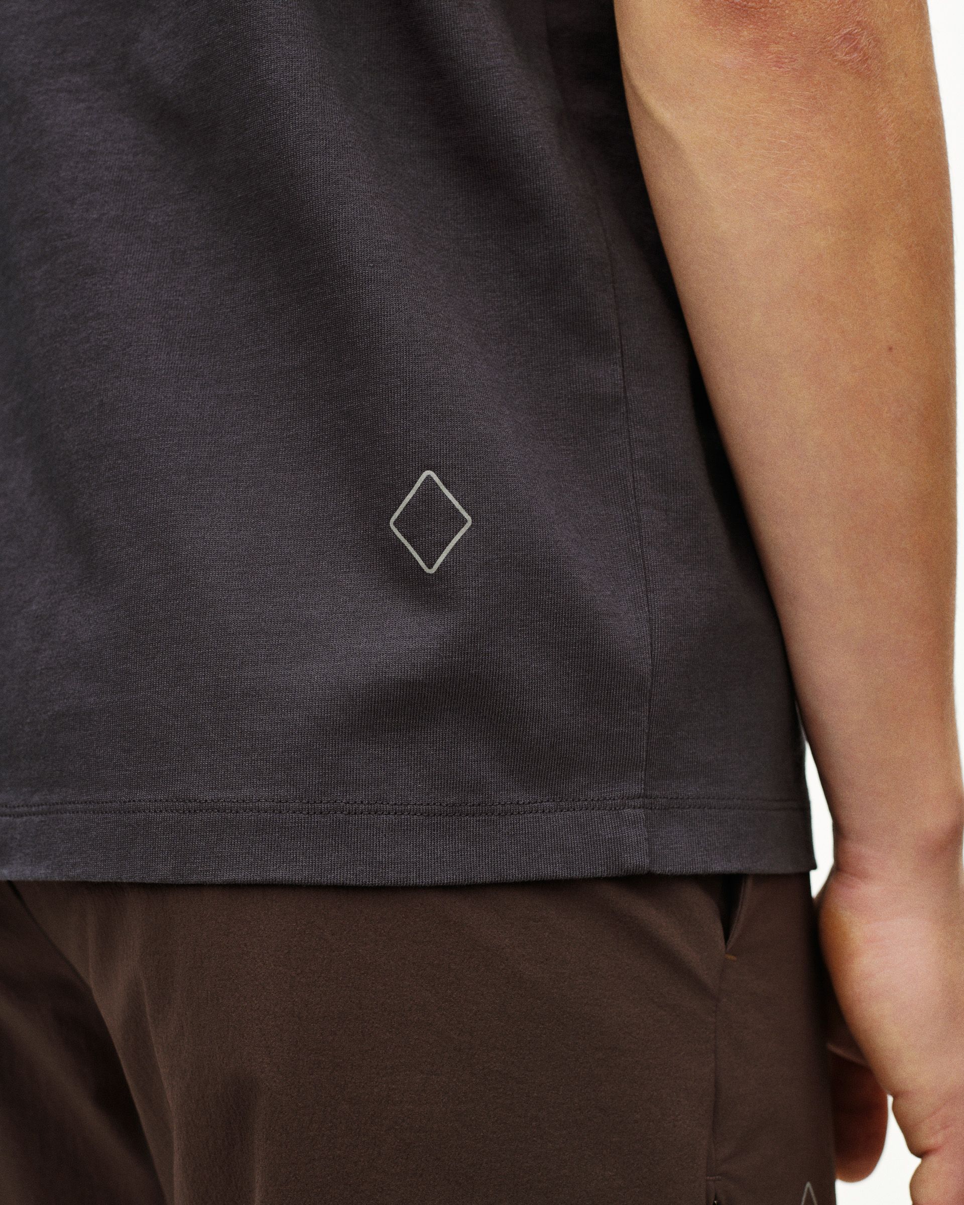 Grey Off-Race t-shirt detail view with white diamond logo on hem