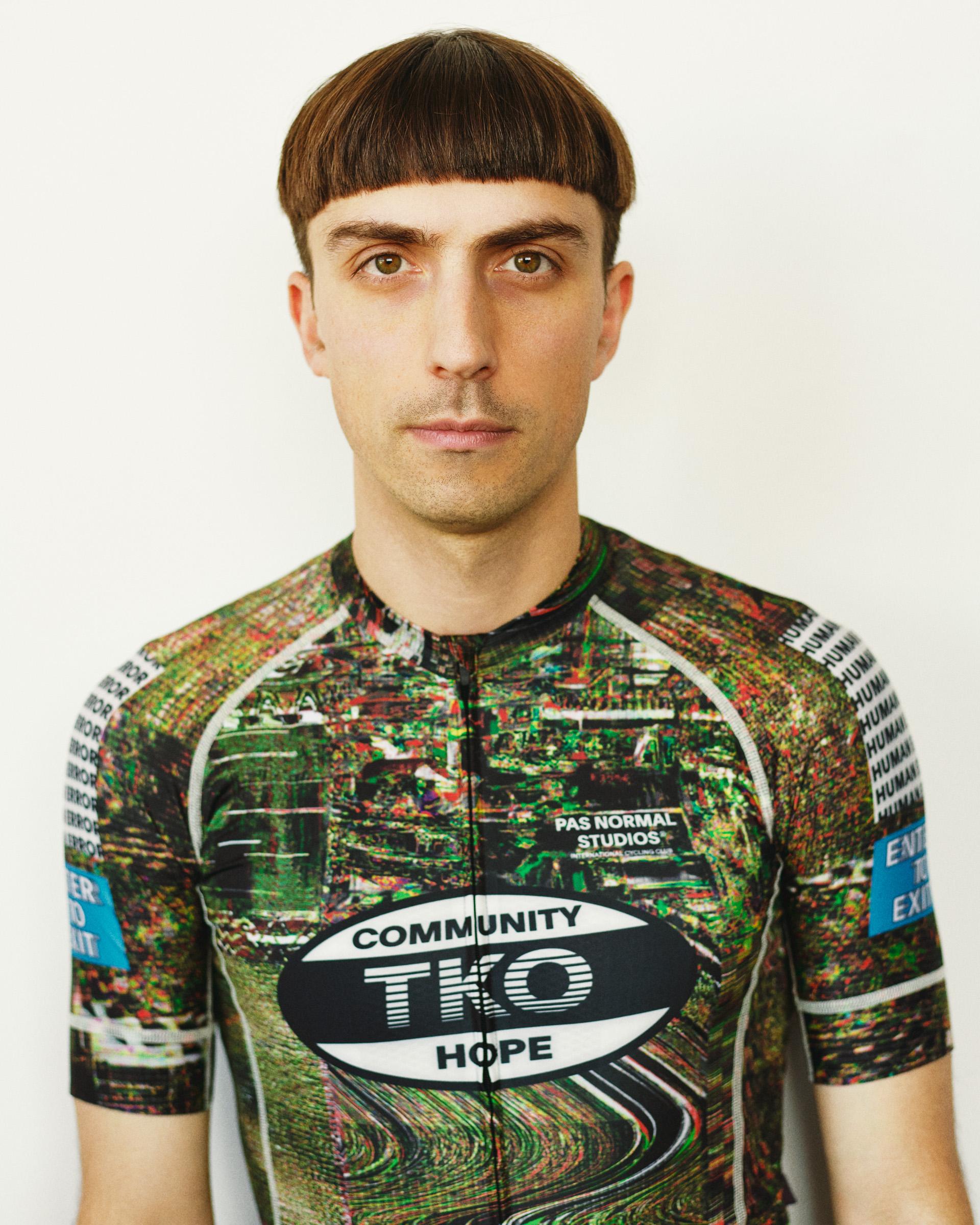 Human Error Green T.K.O. Mechanism cycling jersey on model, front view with all-over graphic print and chest logo