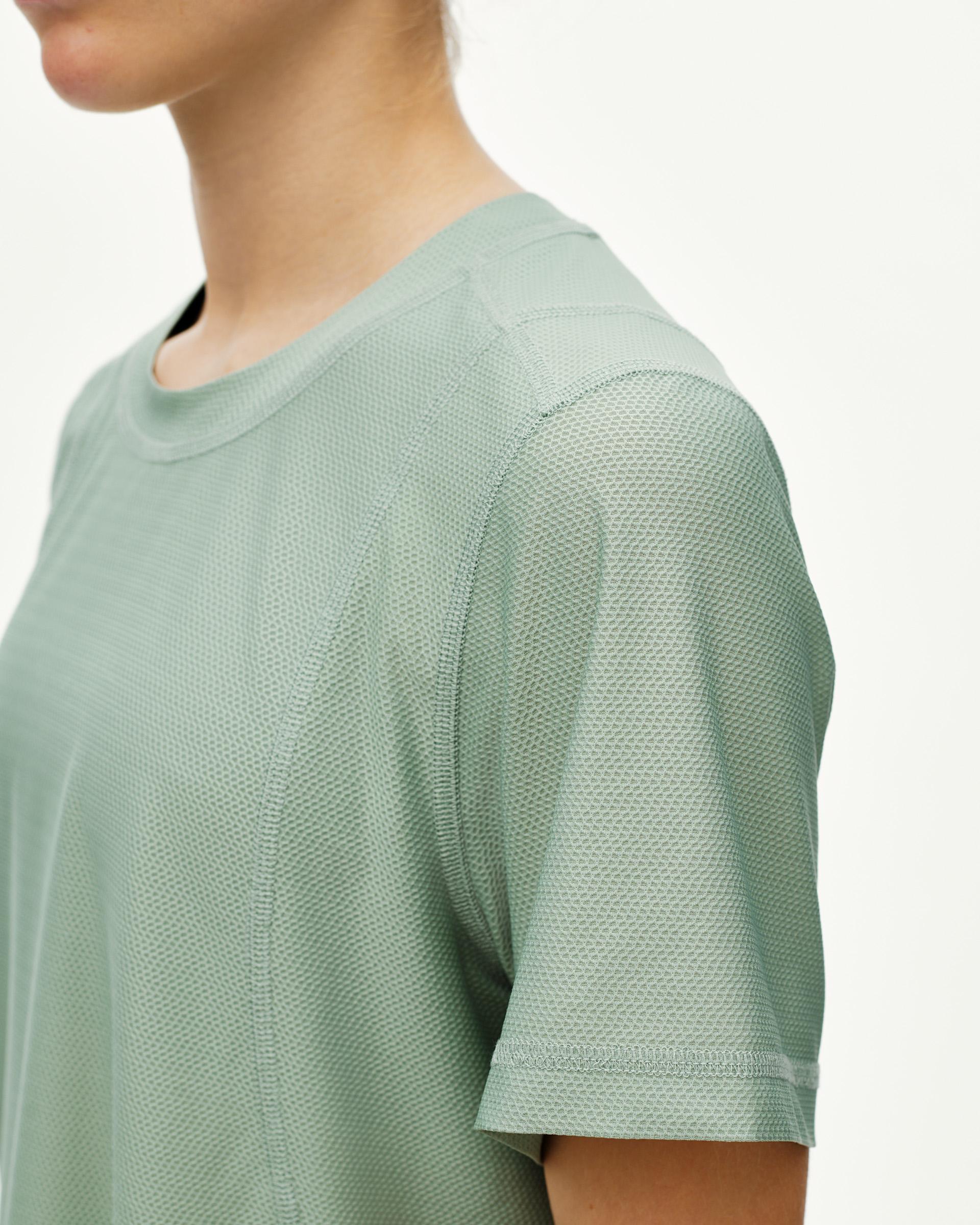 Green Sage Balance women's T-shirt, three-quarter detail on model with textured mesh fabric panel at shoulder