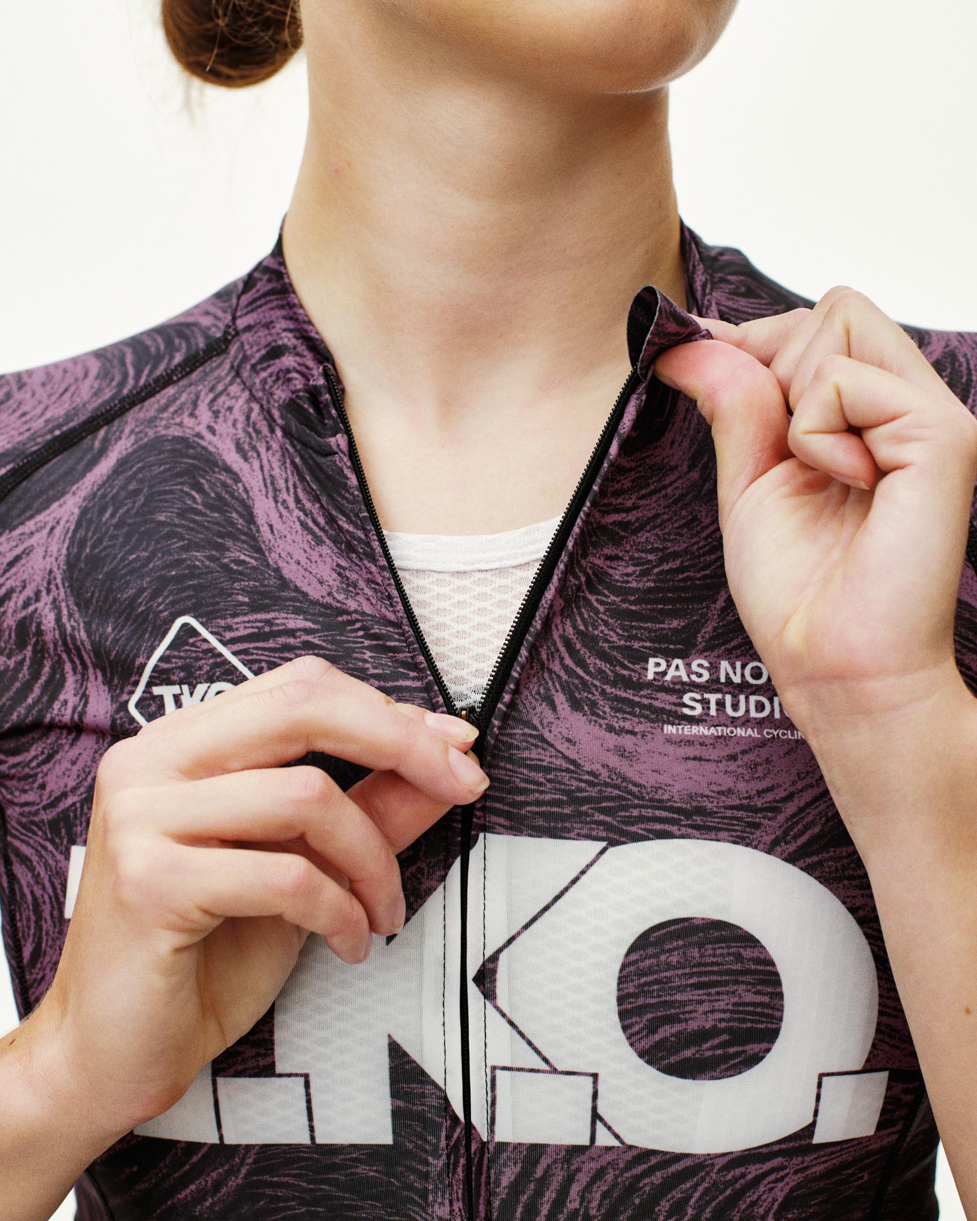 Mauve T.K.O. Mechanism women's cycling jersey, front detail on model showing full-length zip and swirl AOP print