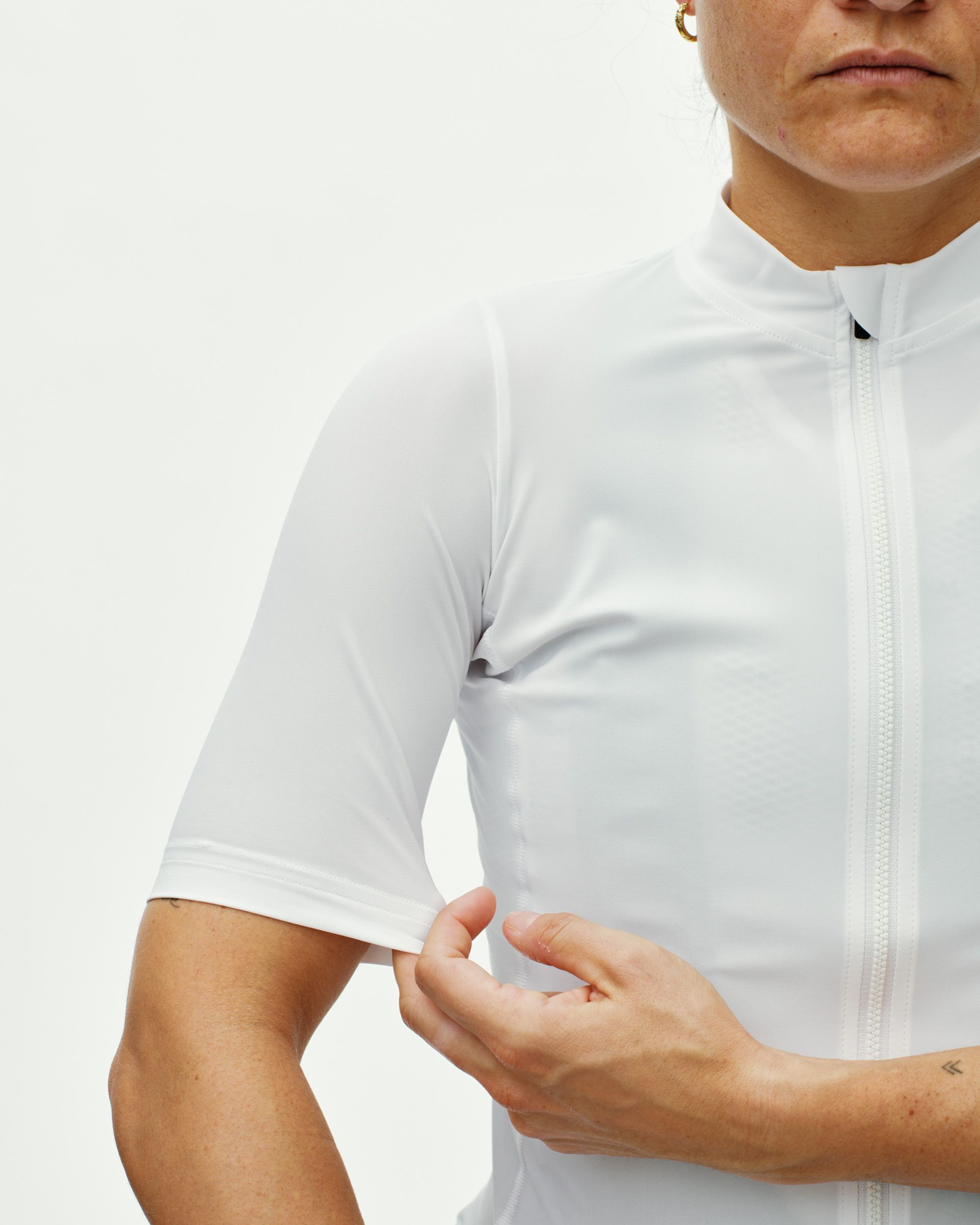 White Essential cycling jersey on model showing front zip and sleeve detail