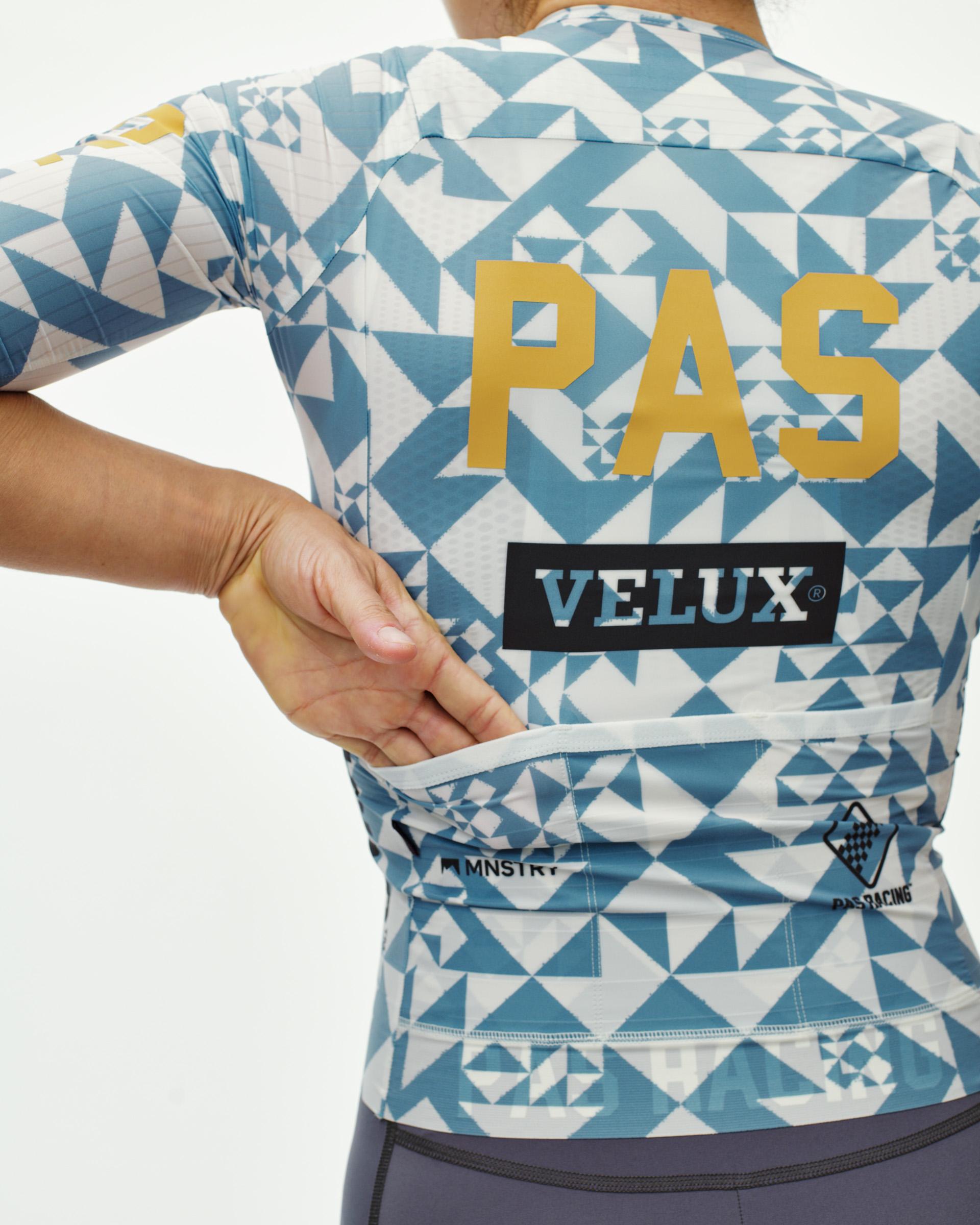 Origami Light Blue PAS Mechanism Pro women's cycling jersey, rear view on model with geometric print and back pockets