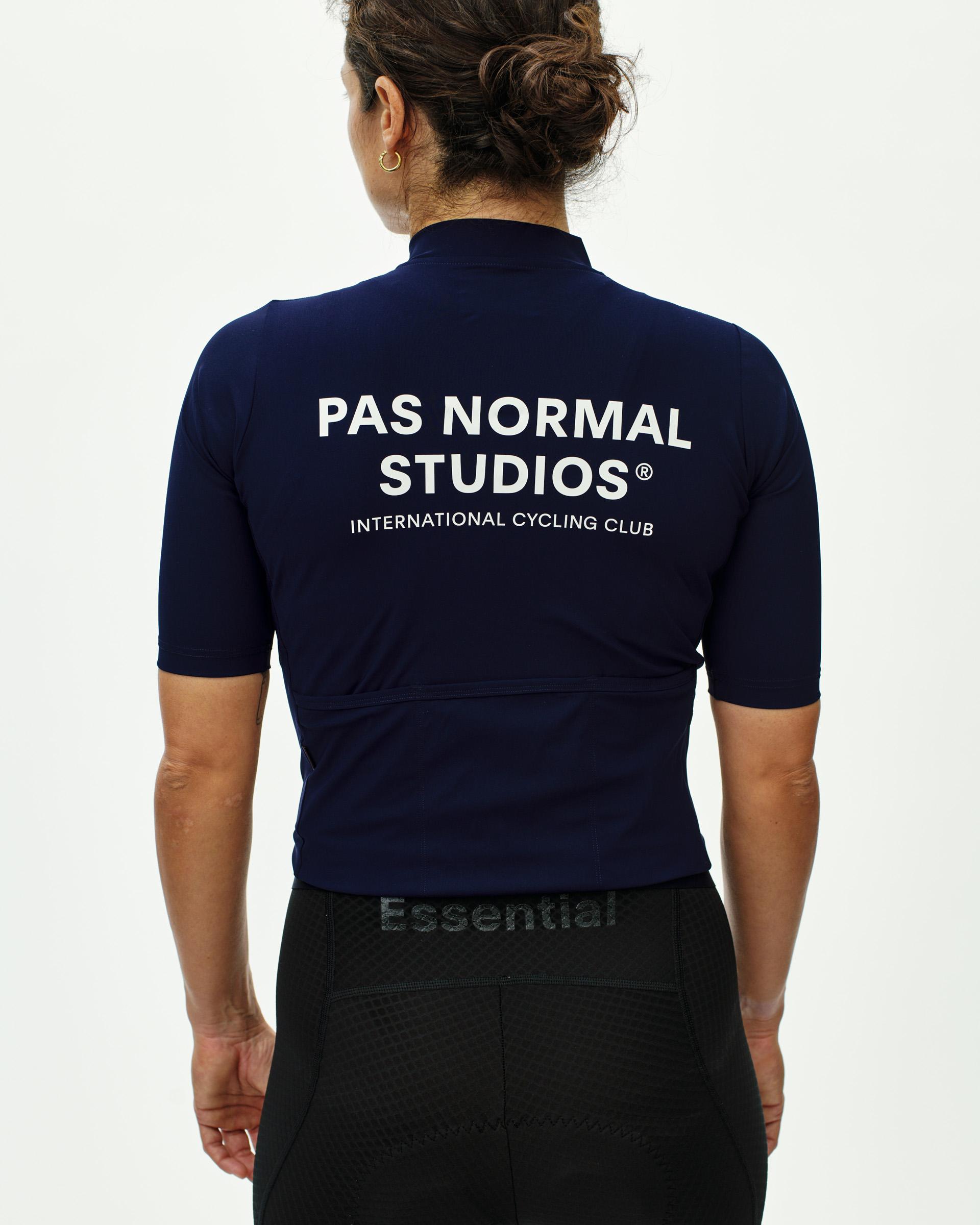 Navy Essential cycling jersey on model, rear view with white logo and text