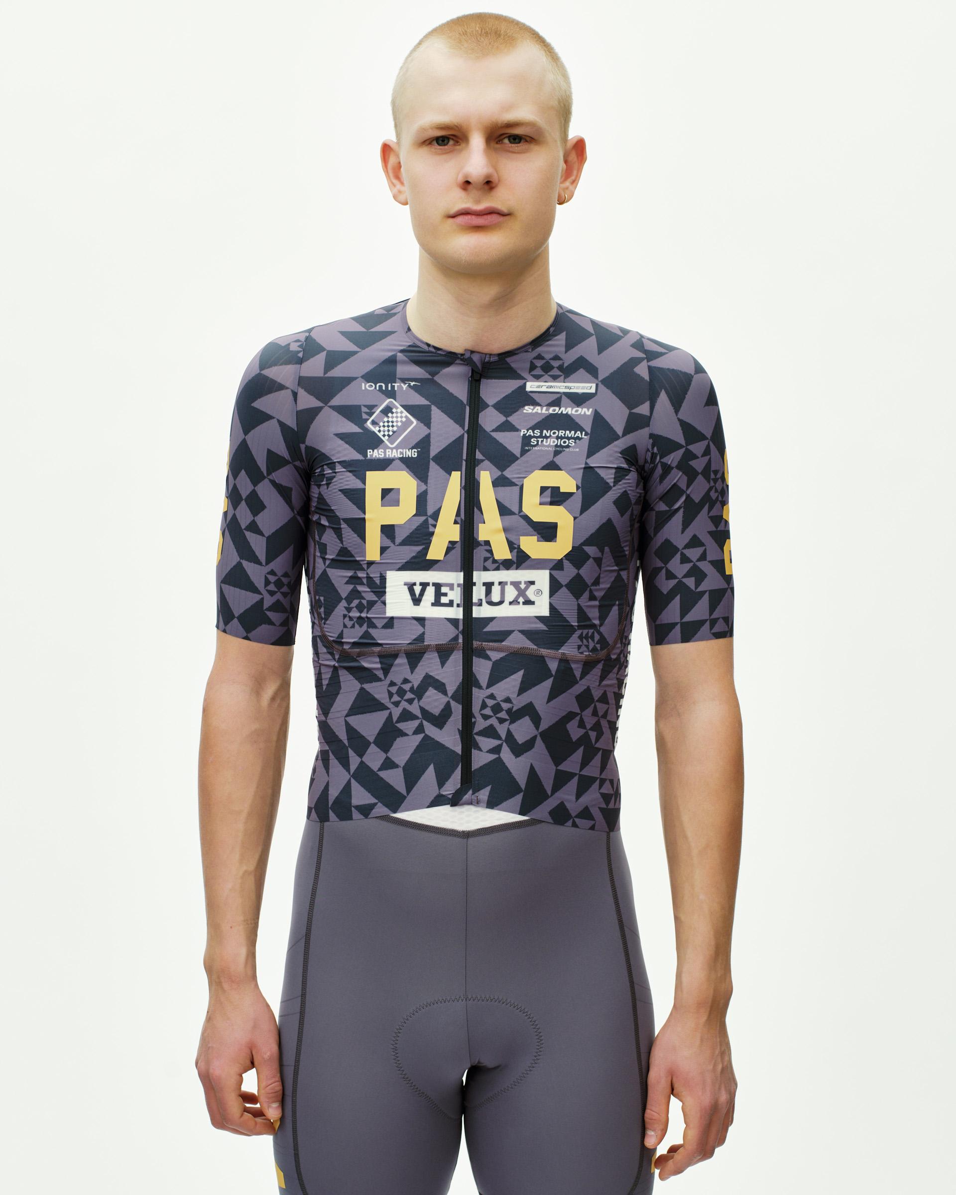 Origami Grey PAS Mechanism Pro cycling jersey on model, front view with geometric print and gold PAS Racing chest graphic