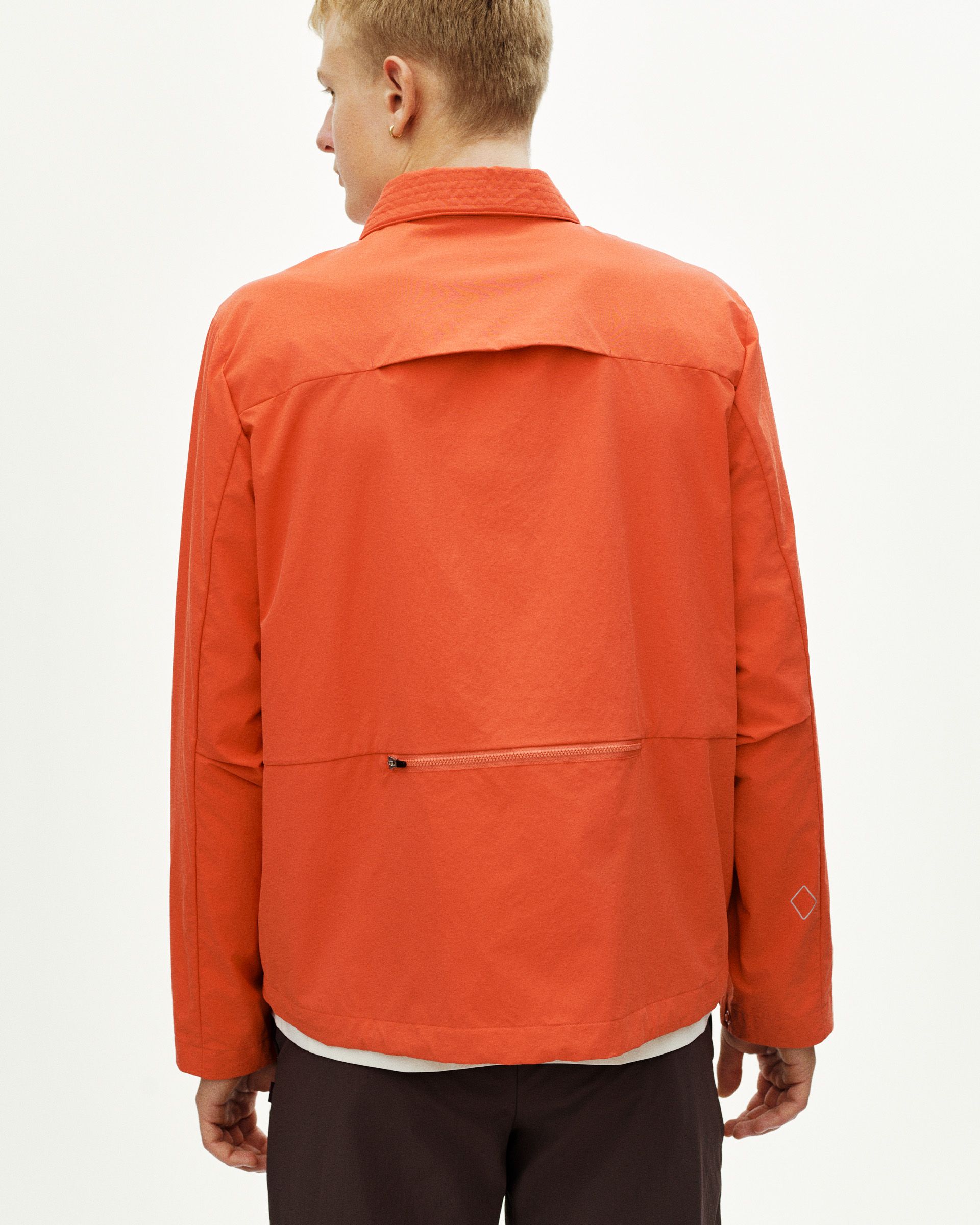 Orange Off-Race Utility jacket, rear view on model with zip pocket and diamond logo