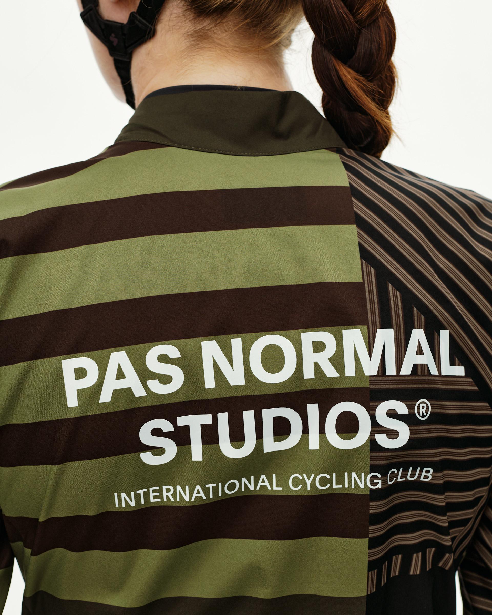 International Green Mechanism Stow Away women's cycling jacket, rear view on model with bold stripe print and back logo