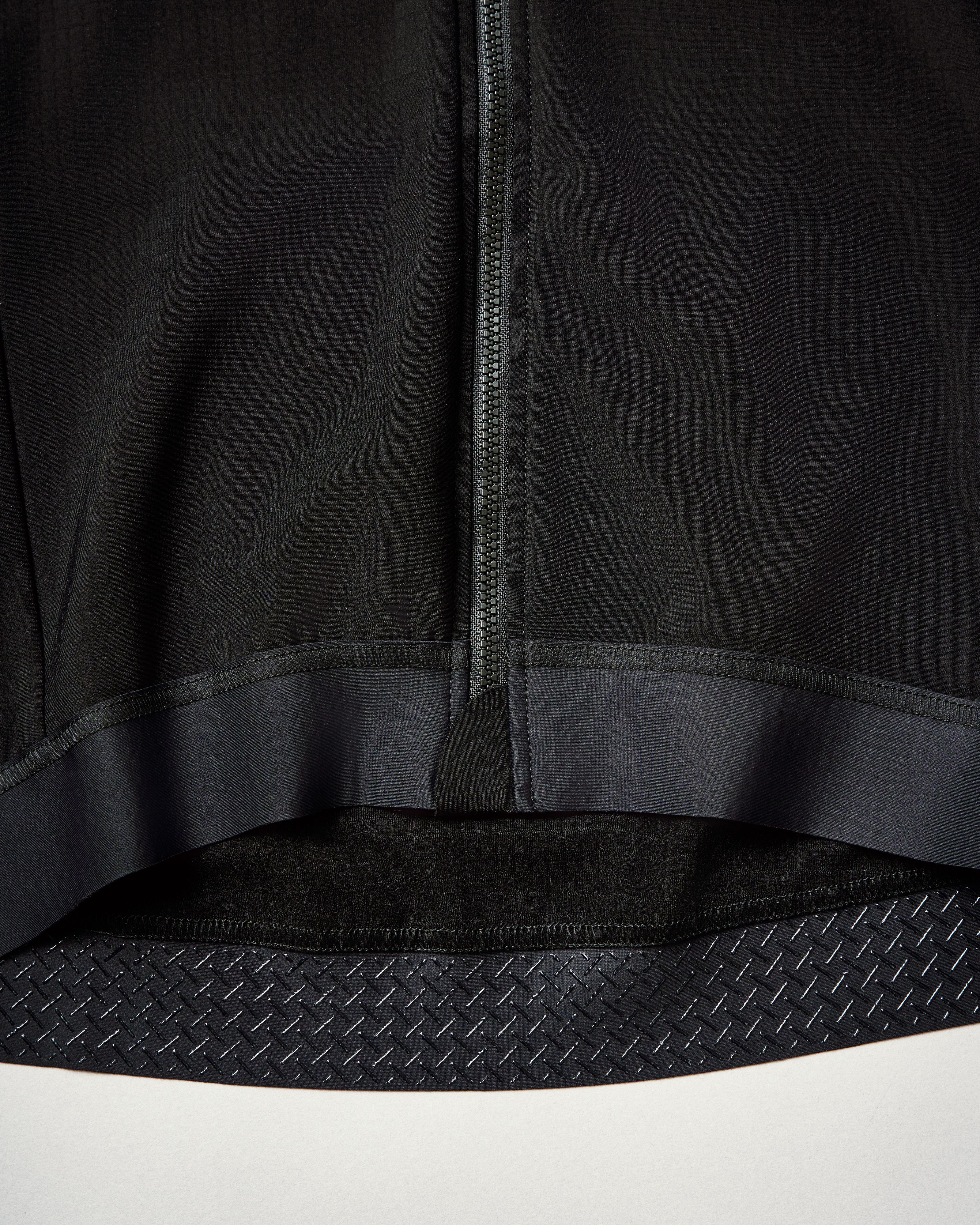 YKK zipper running down center front with silicone gripper tape at hem for secure fit