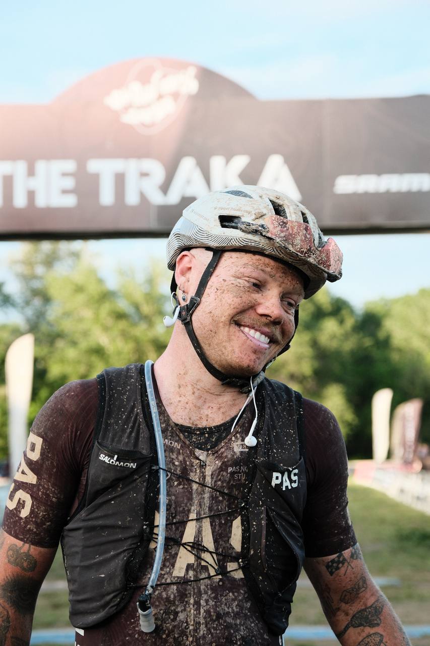Model wearing black PAS collection cycling jersey and helmet after muddy gravel race