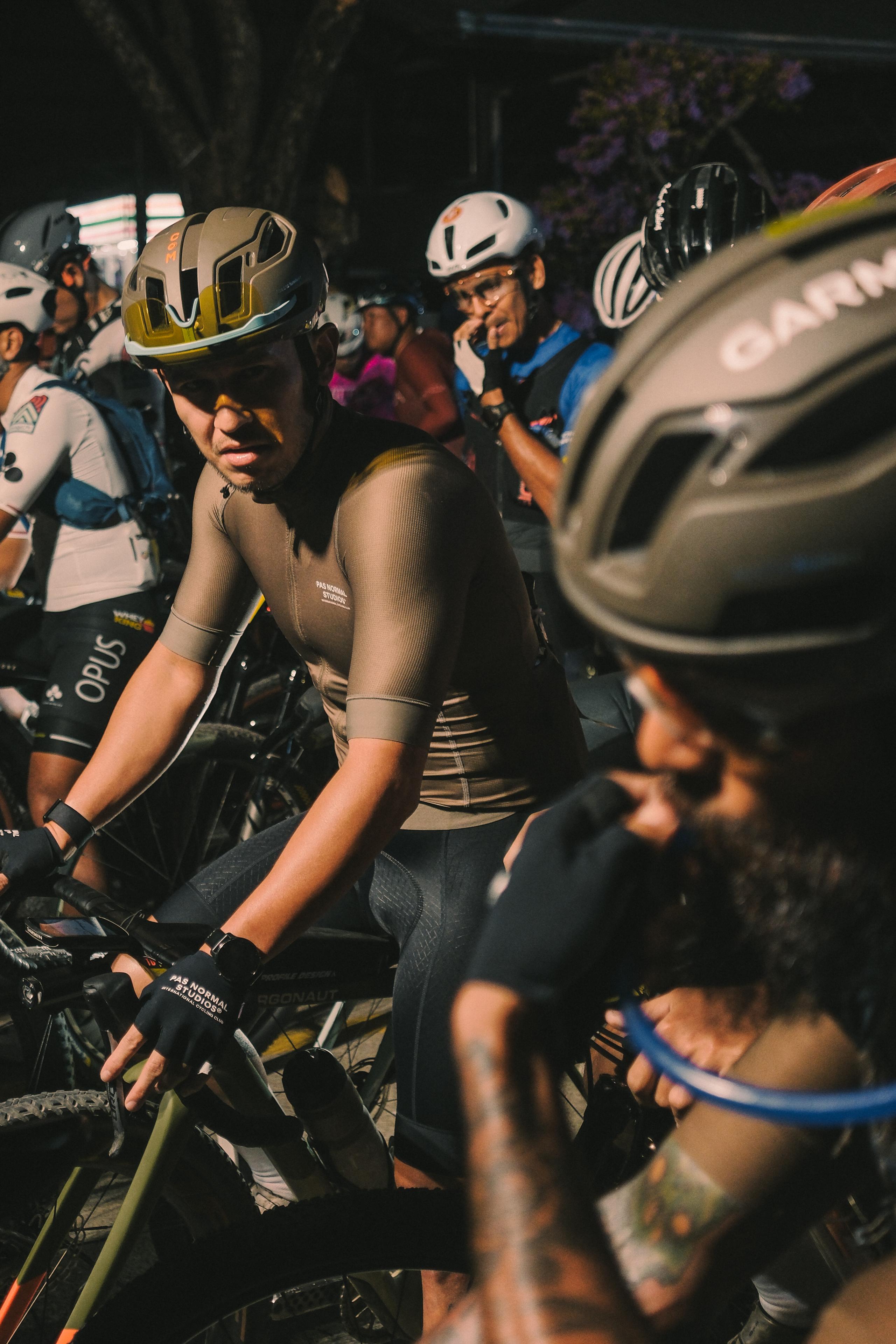 Cyclist in aerodynamic position wearing brown skinsuit and helmet during gravel race start