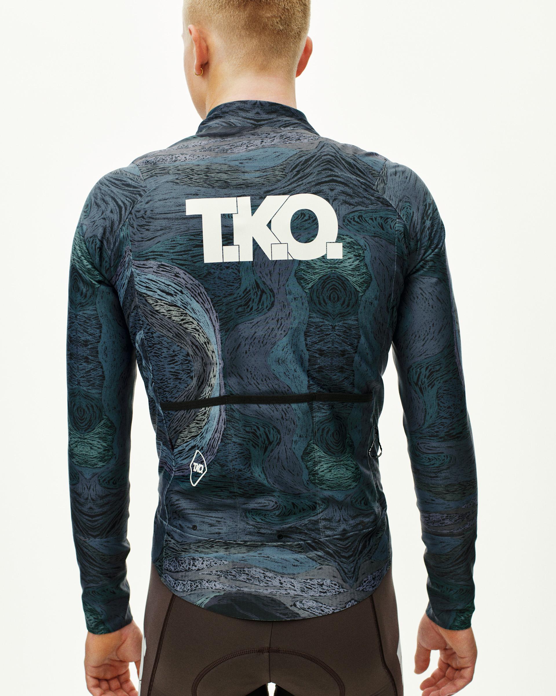 Dark Multi T.K.O. Mechanism Thermal cycling jacket on model, rear view with allover swirl print and white T.K.O. back logo