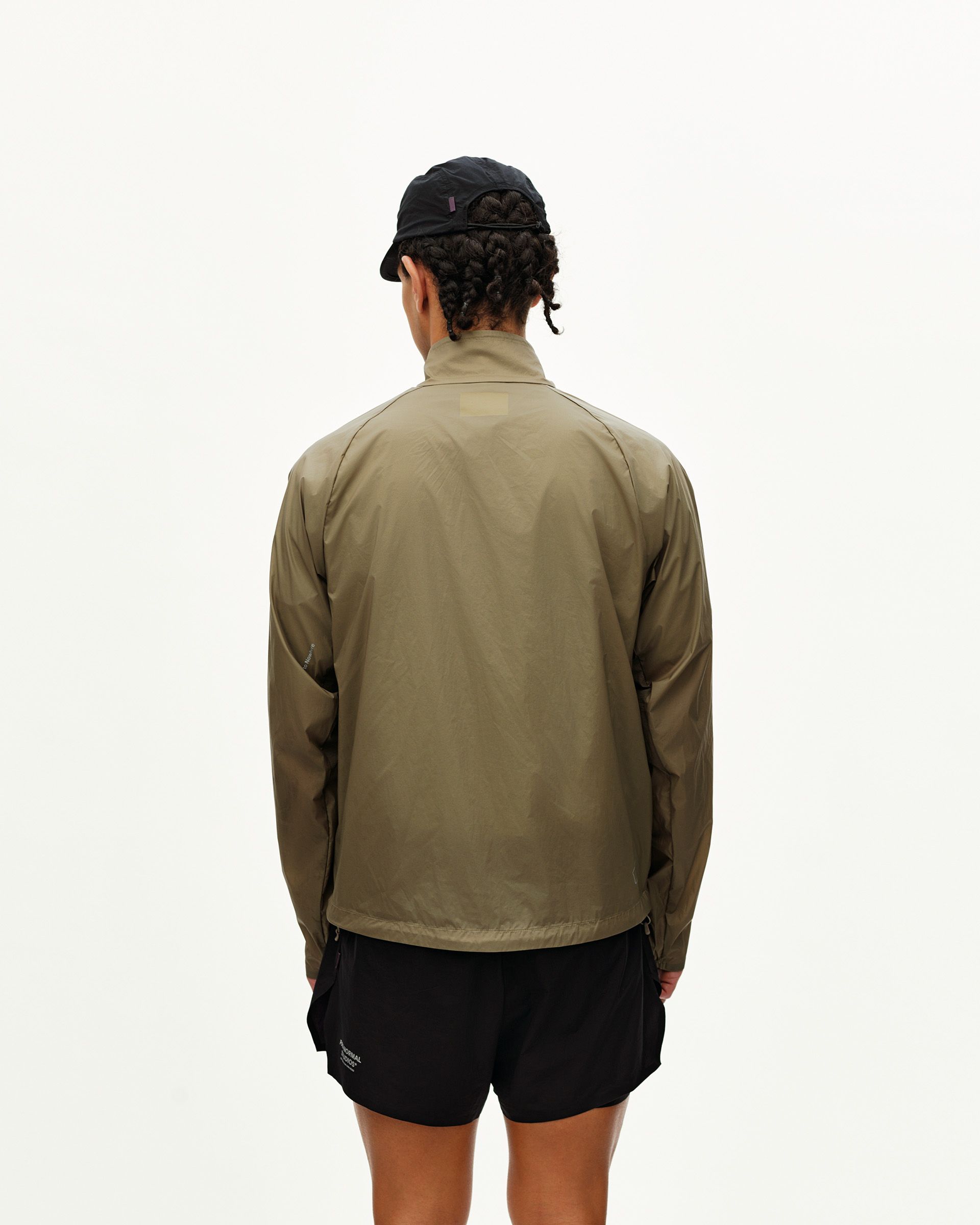 Dusty Earth khaki Balance Windproof jacket on model, rear view with zip side pockets