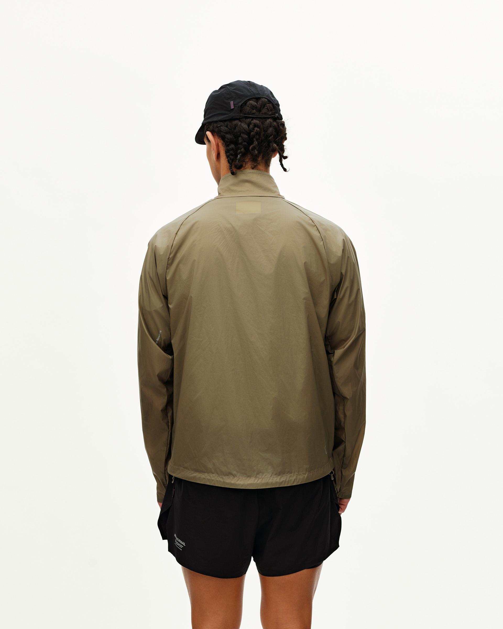 Dusty Earth khaki Balance Windproof jacket on model, rear view with zip side pockets