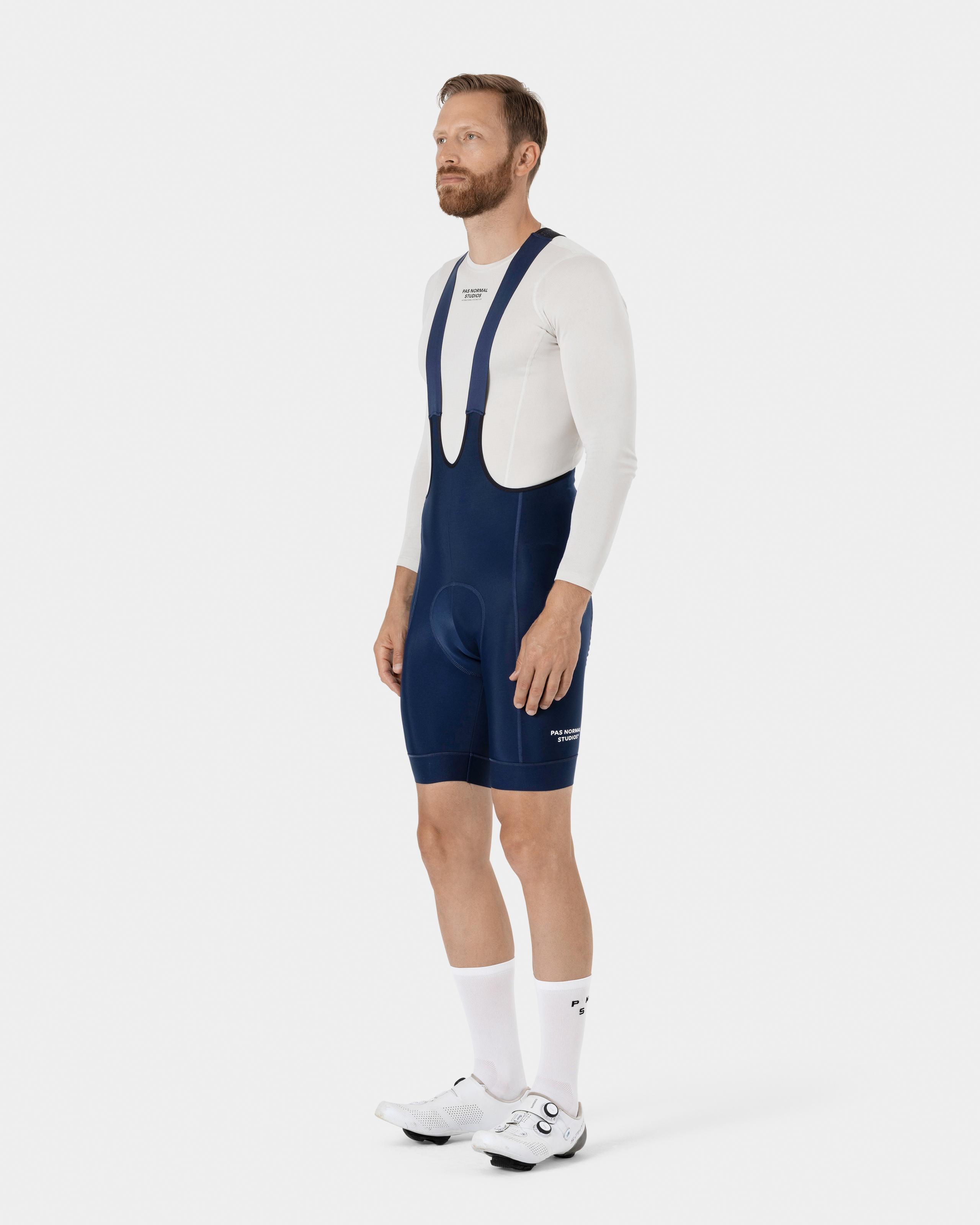 Navy Essential cycling bibs on model, three-quarter view with thermal bib straps