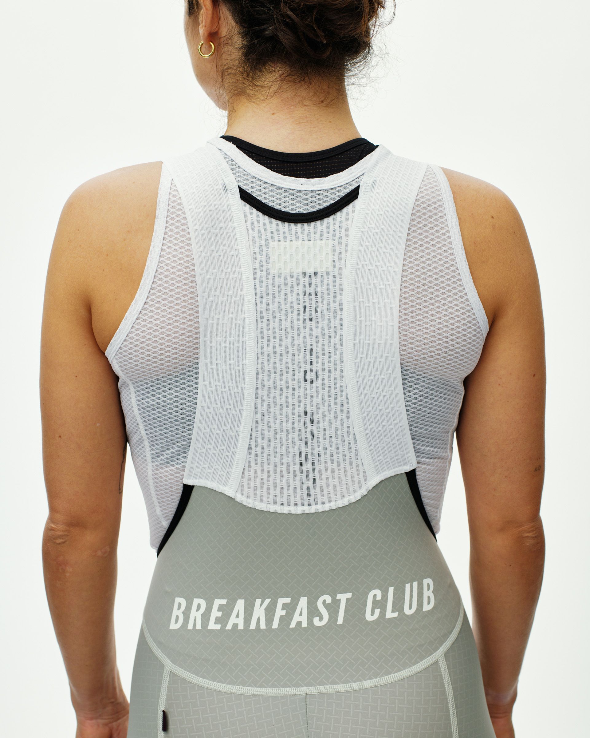 Light Grey Mechanism Breakfast Club women's cycling bibs, rear view on model with white waistband text detail