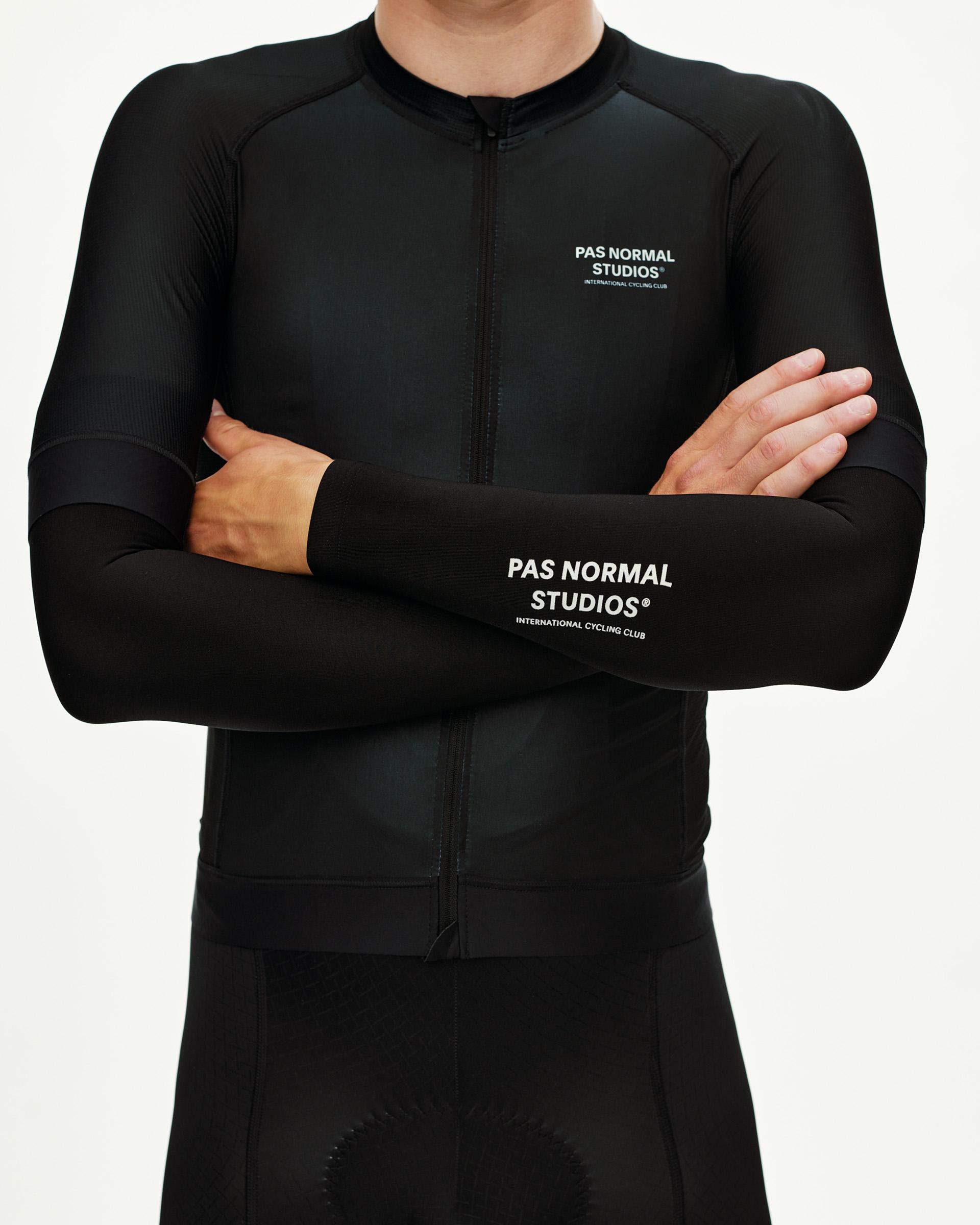 Black Logo cycling arm warmers on model, front view with white chest print