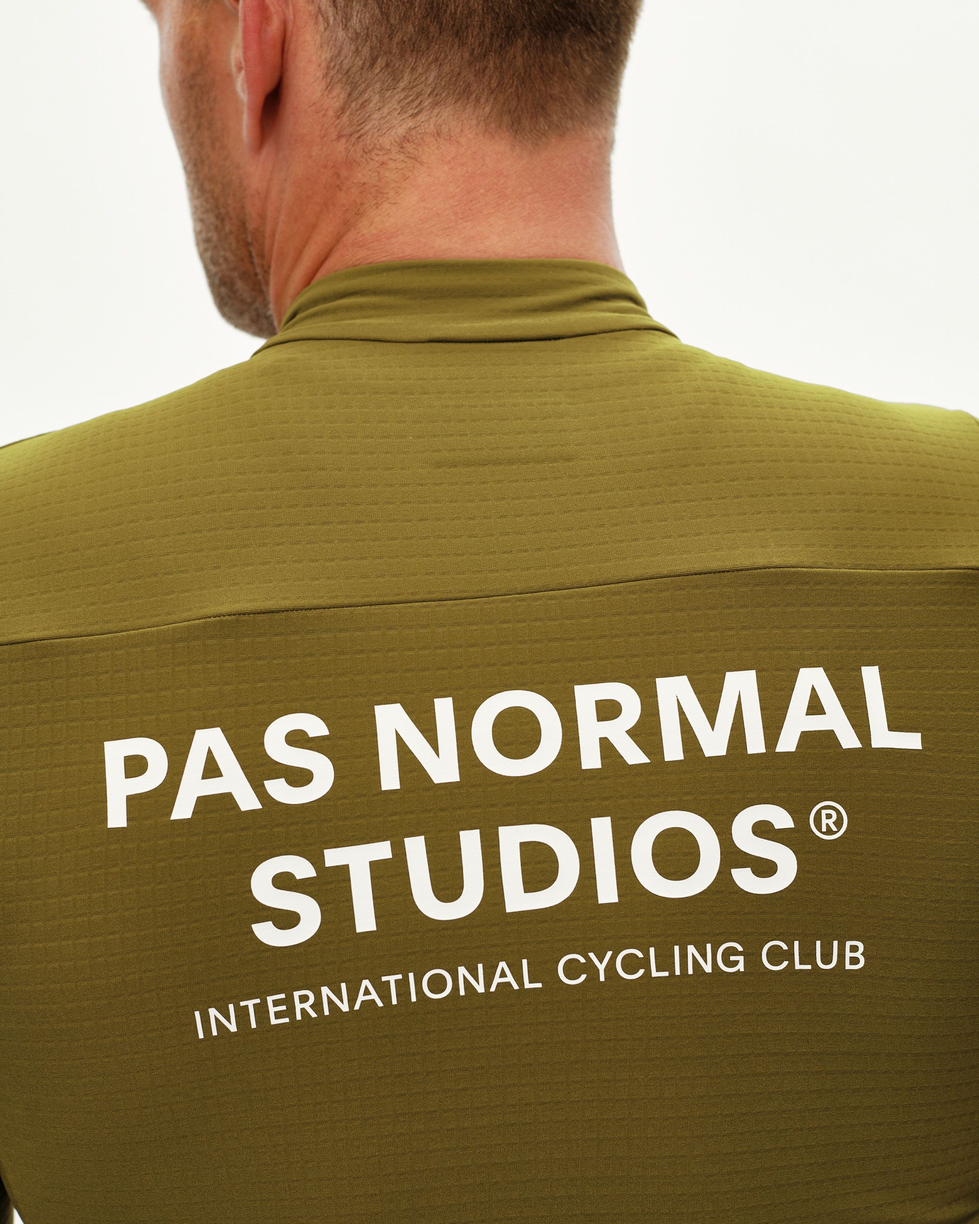 Khaki Green Essential long sleeve cycling jersey, rear detail on model with white logo print