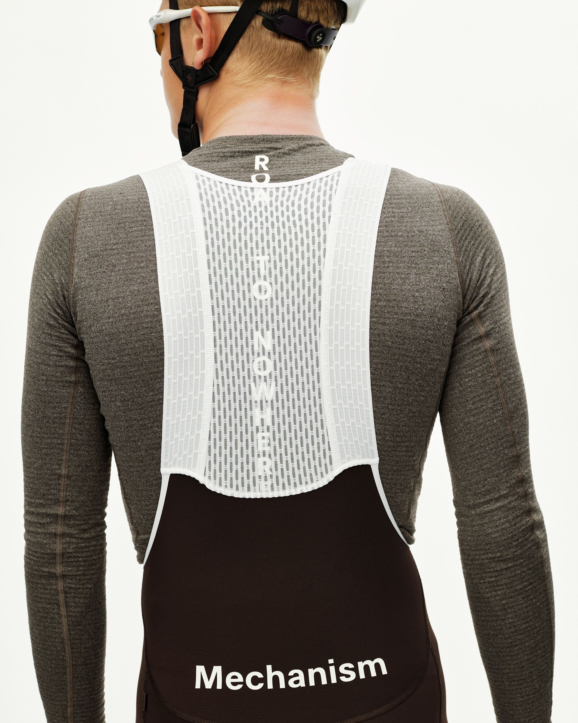 Dark Coffee Mechanism Thermal Long cycling bibs on model, rear view with white mesh bib straps and text print