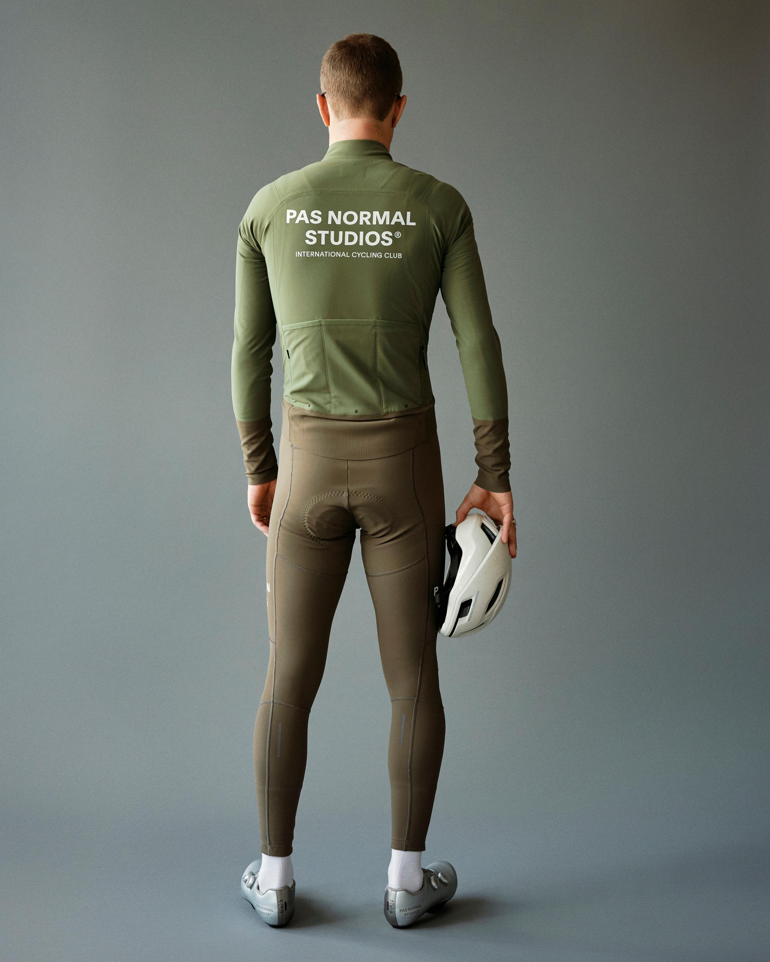 Green Mechanism Thermal cycling jacket on model, rear view with white logo print