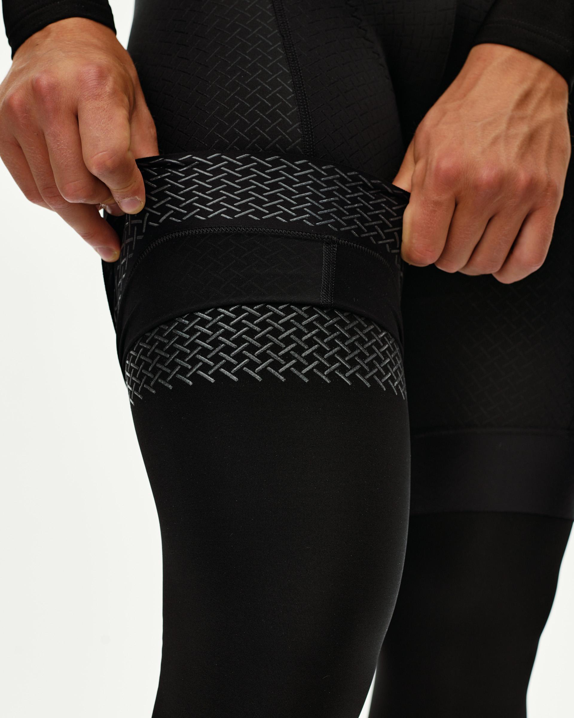 Black Logo cycling knee warmers, detail on model showing textured woven pattern band at upper leg