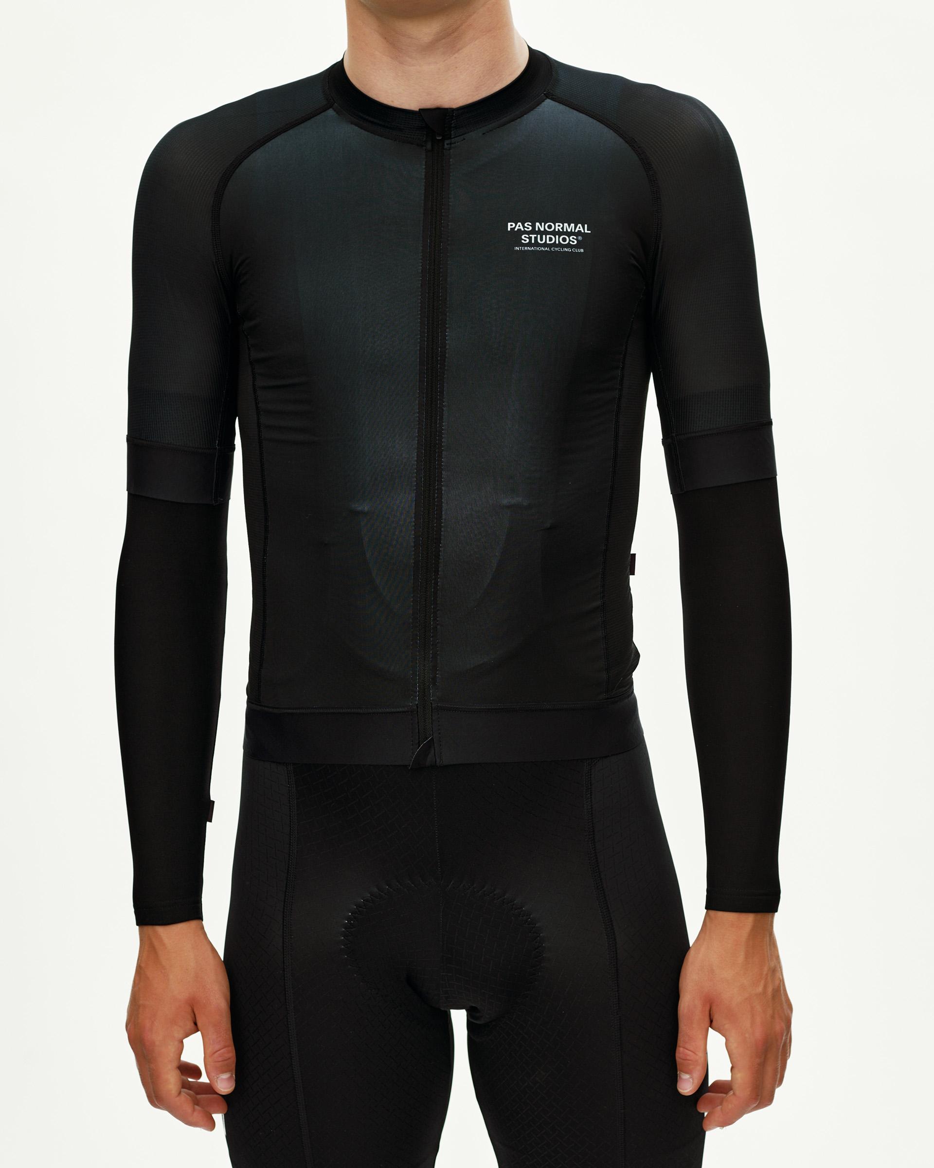 Black cycling arm warmers, front view on model with ribbed cuff and fitted sleeve