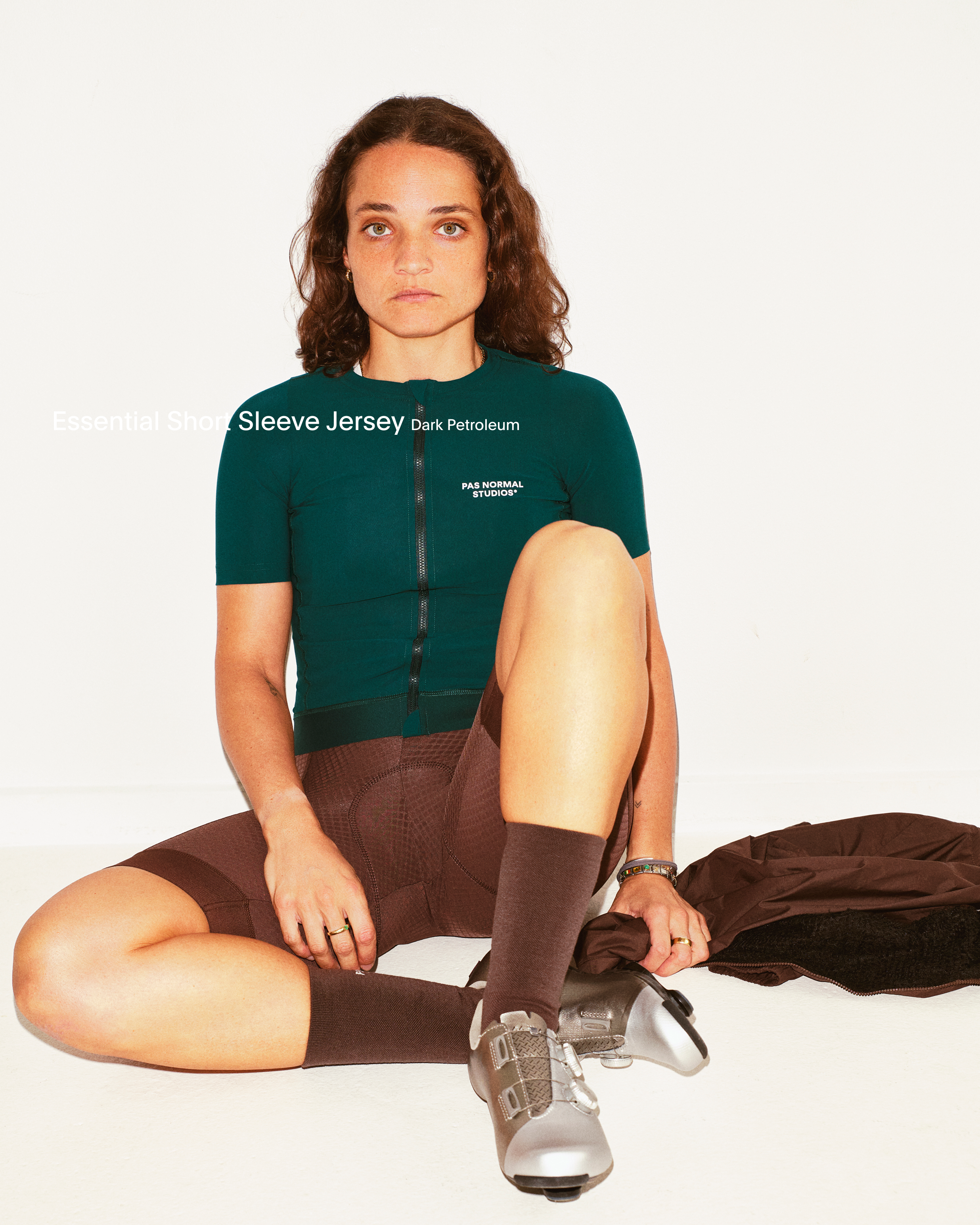 Model wearing Women's Sleeve Jersey in dark green with brown shorts, studio shot