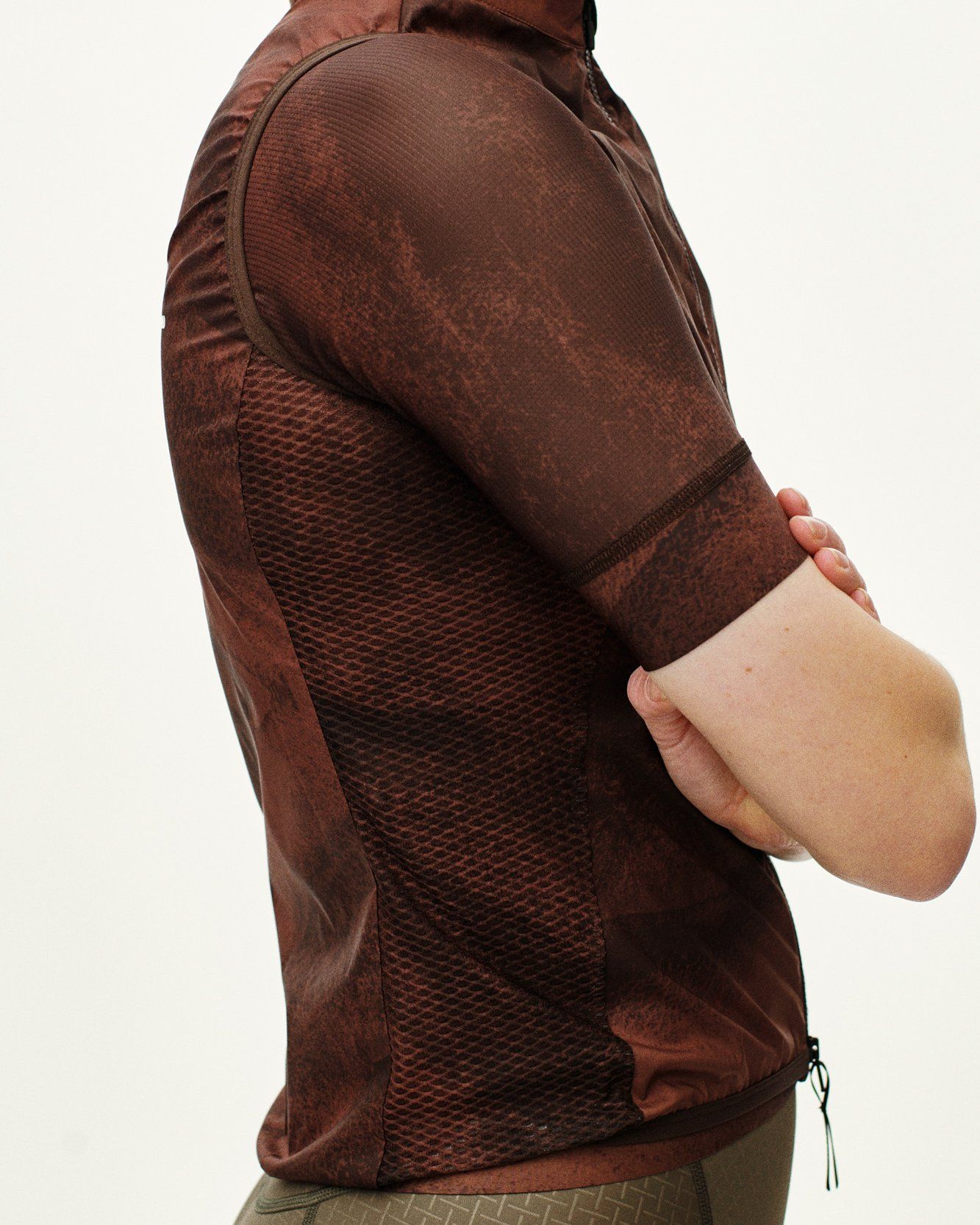 Brown Mechanism Stow Away gilet, side view on model with mesh panels and drawstring hem