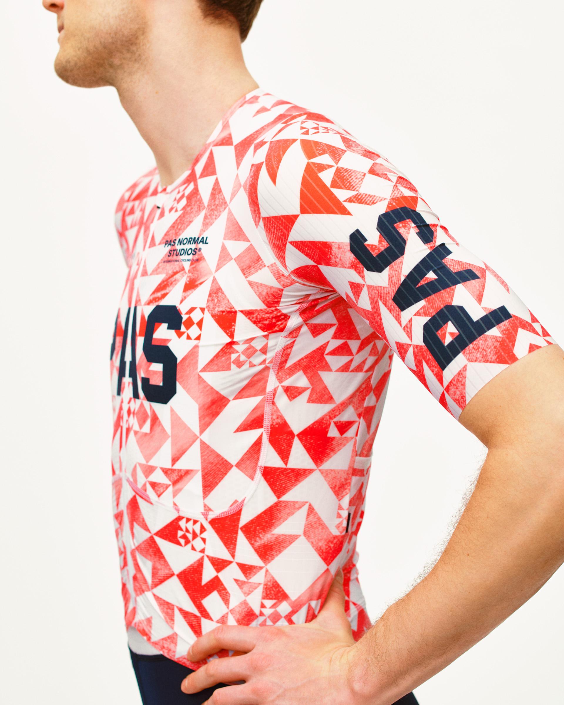 Red PAS Mechanism Pro cycling jersey on model, side view with geometric origami print