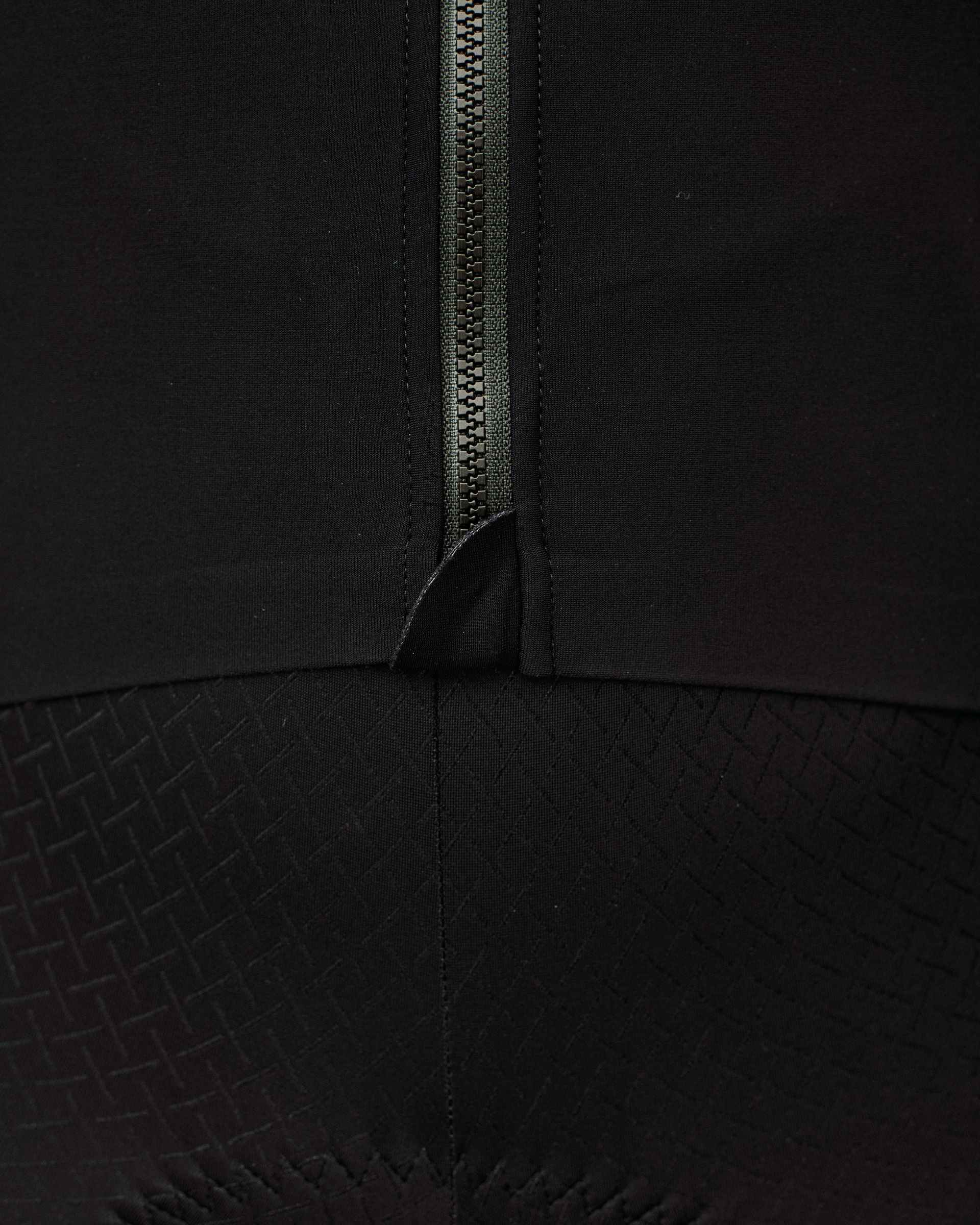 Black Mechanism long sleeve cycling jersey, detail view of front zip and textured lower panel