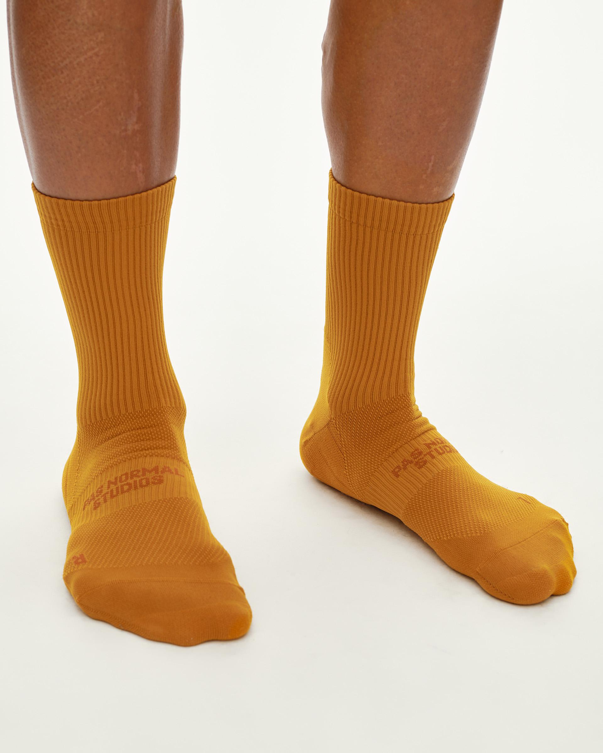 Ochre Balance cycling socks on model, front view with ribbed cuff and tone-on-tone logo print