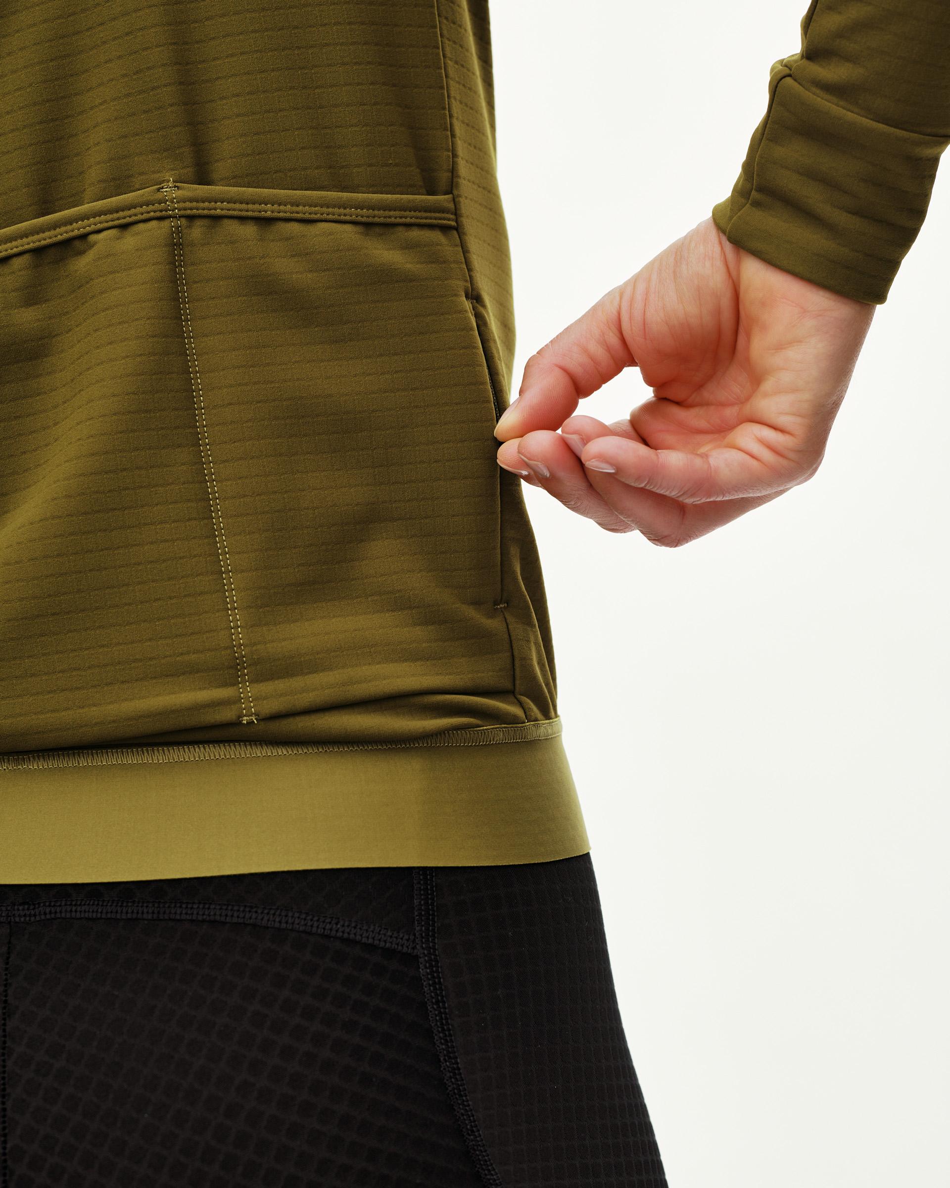 Khaki Green Essential cycling jersey, side detail on model showing ribbed hem and rear pocket