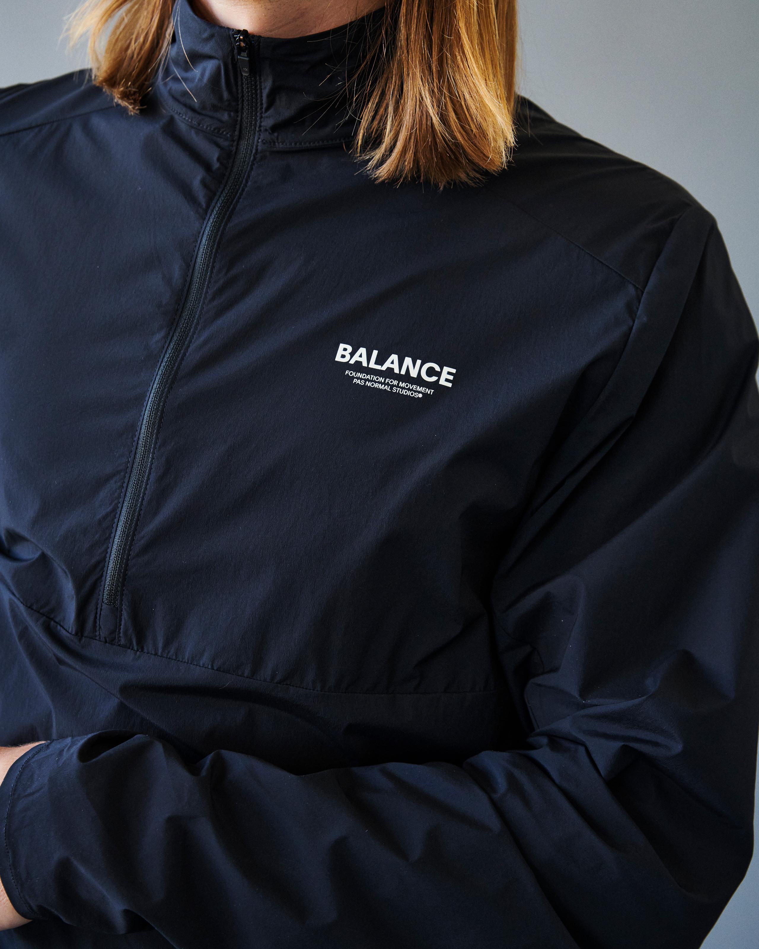 Navy Balance Half Zip jacket on model with white chest logo and partial zip closure