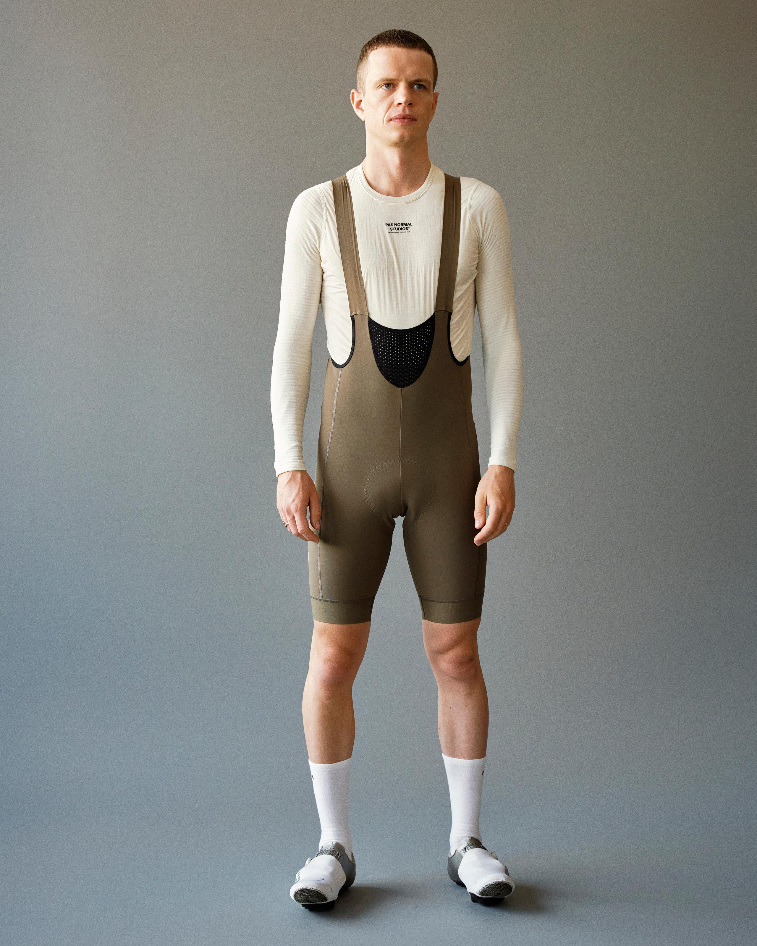 Dark Stone Mechanism Deep Winter cycling bibs on model with high bib front and perforated chest panel