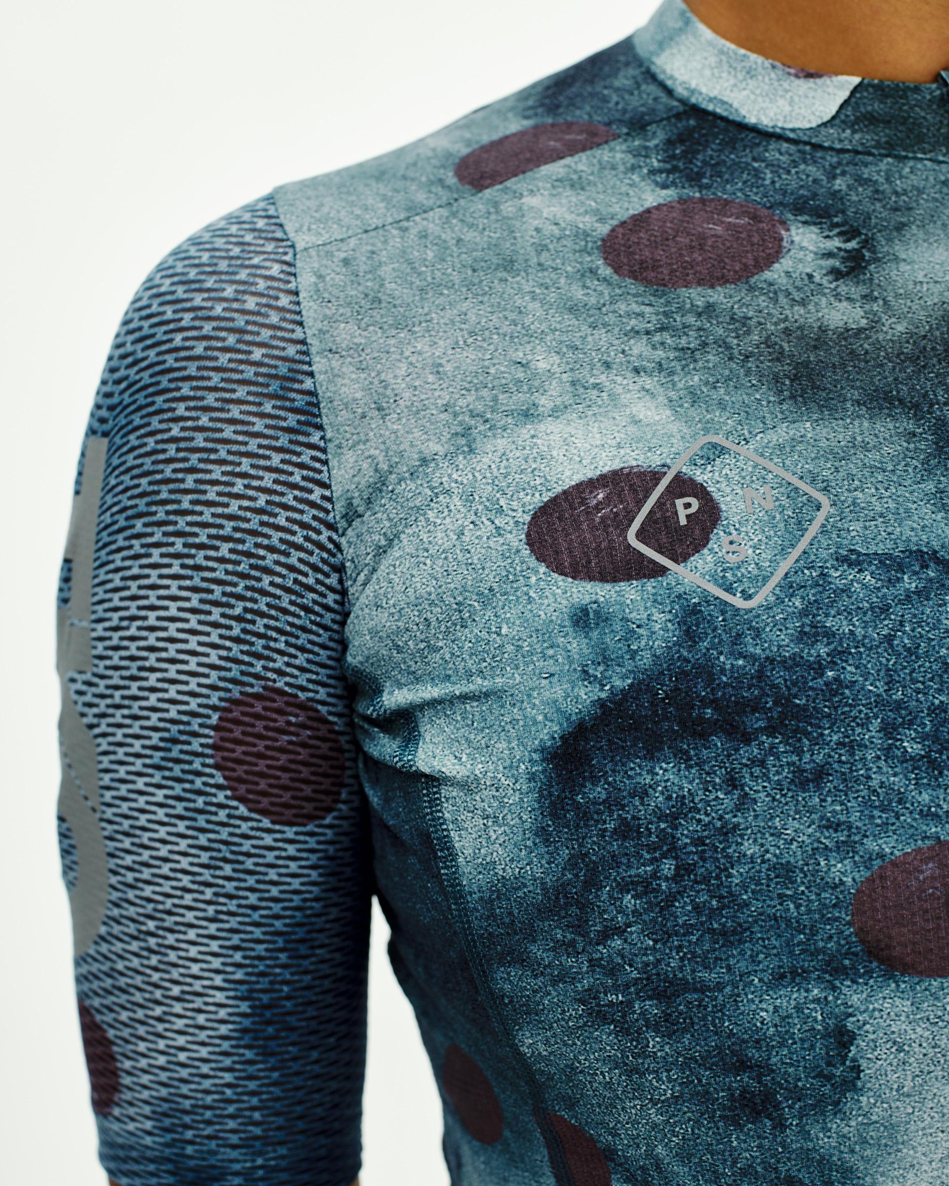 Dark Purple T.K.O. Essential Light cycling jersey on model with abstract print and chest logo
