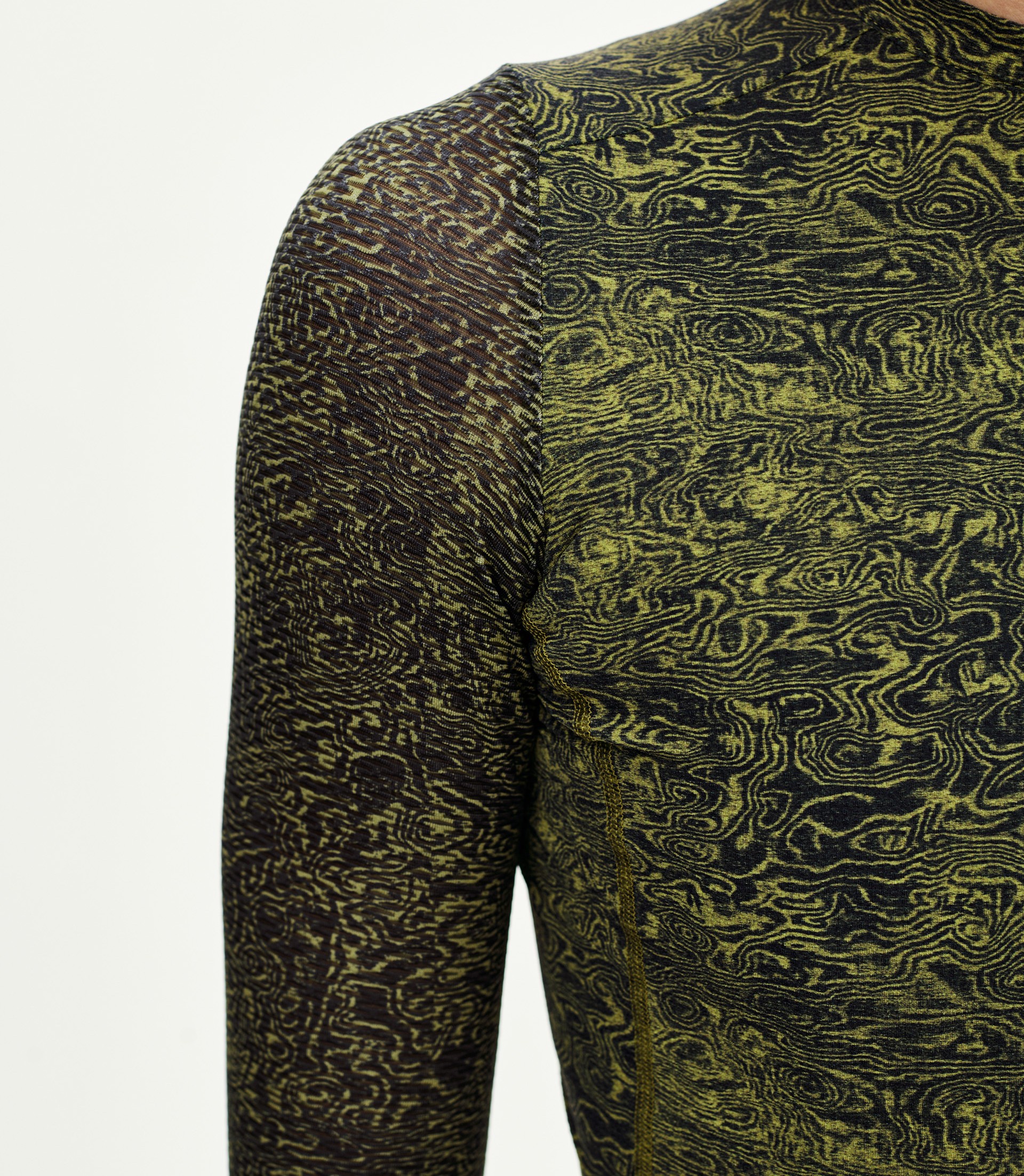 Dark Lime Essential long sleeve cycling jersey, detail view on model with all-over swirl print